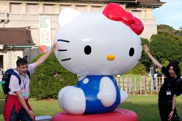 <p>Tourists from Britain pose with Hello Kitty decoration at the Tokyo National Museum</p>