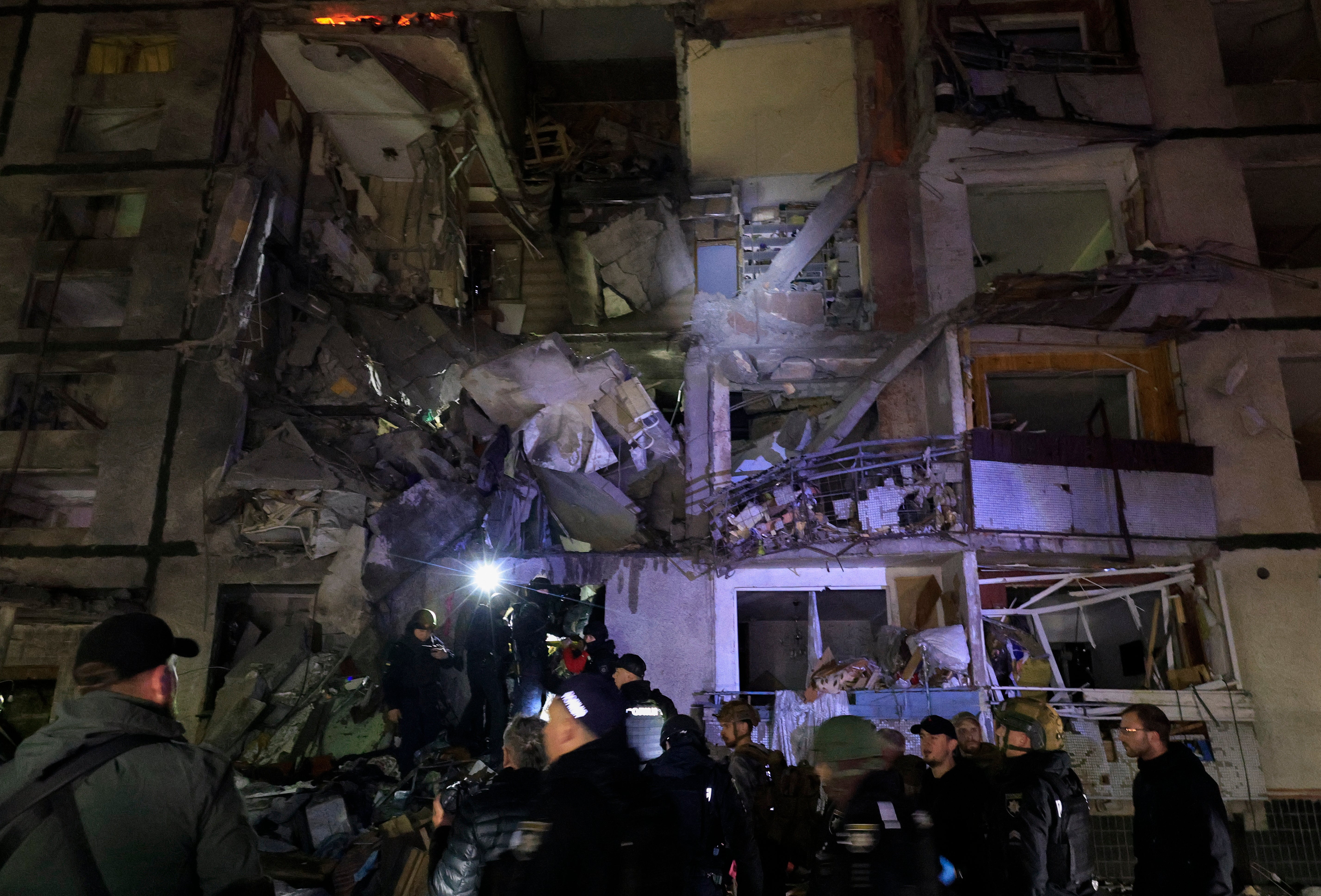 Ukrainian rescuers working at the site of a Russian glide-bomb attack late at night on a nine-flour residential building in Kharkiv