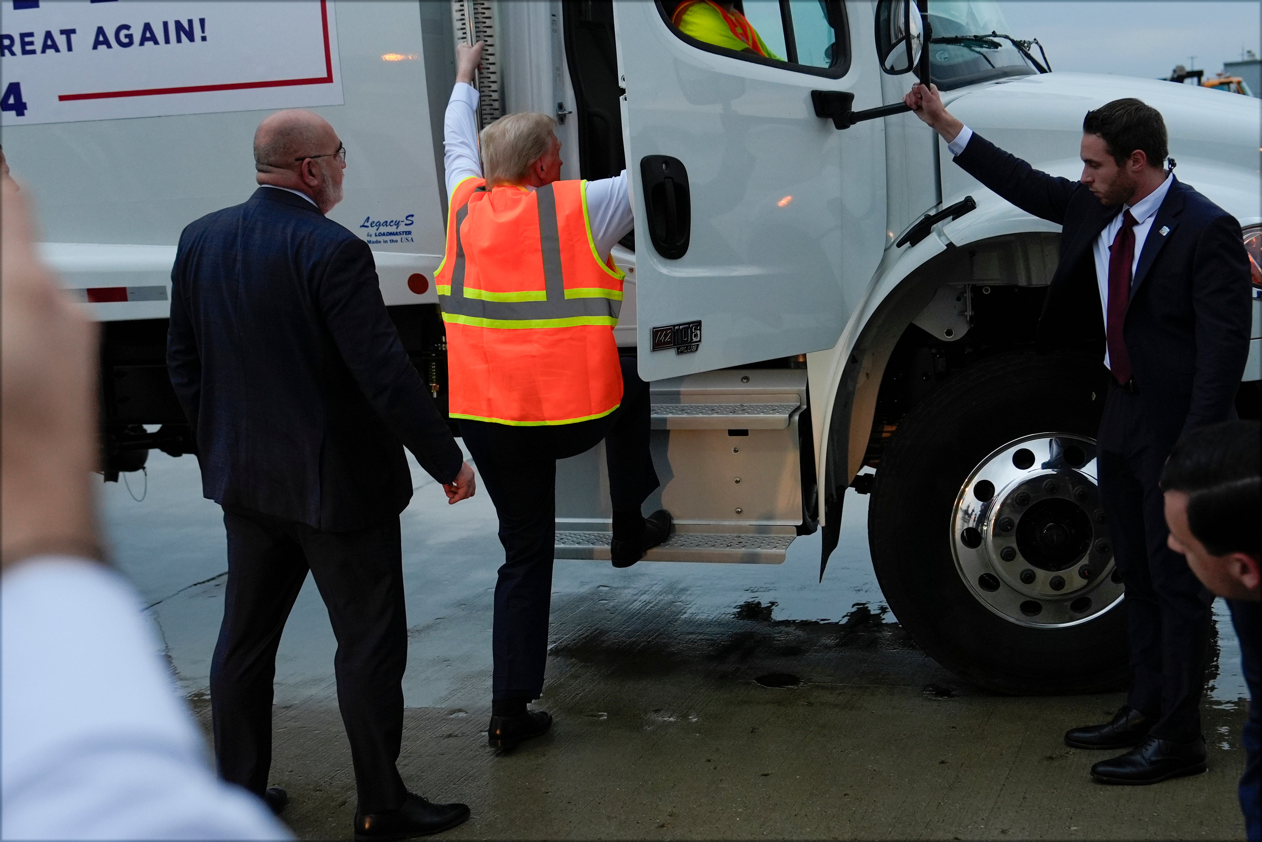 Trump appears to struggle to clamber inside the truck