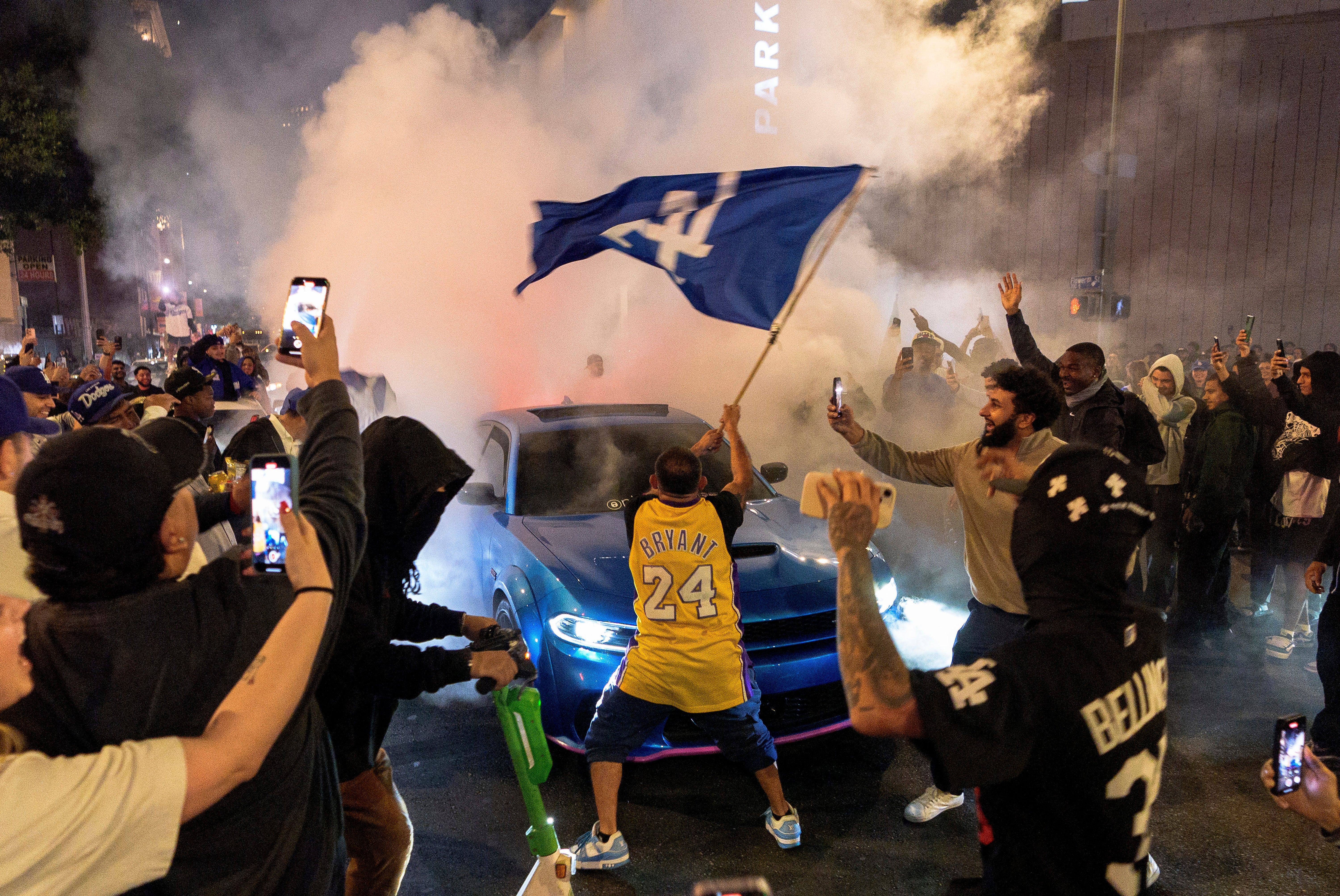 Fans celebrate on the streets after the Los Angeles Dodgers won against the New York Yankees in the baseball World Series Wednesday, Oct. 30, 2024, in downtown Los Angeles