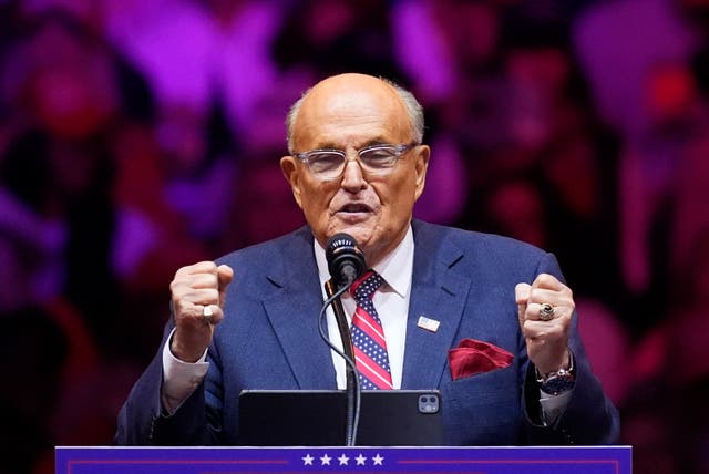 <p>Rudy Giuliani speaks a crowd in New York City. Lawyers for the election workers he defamed claim he is not ‘ready’ to hand over his property </p>