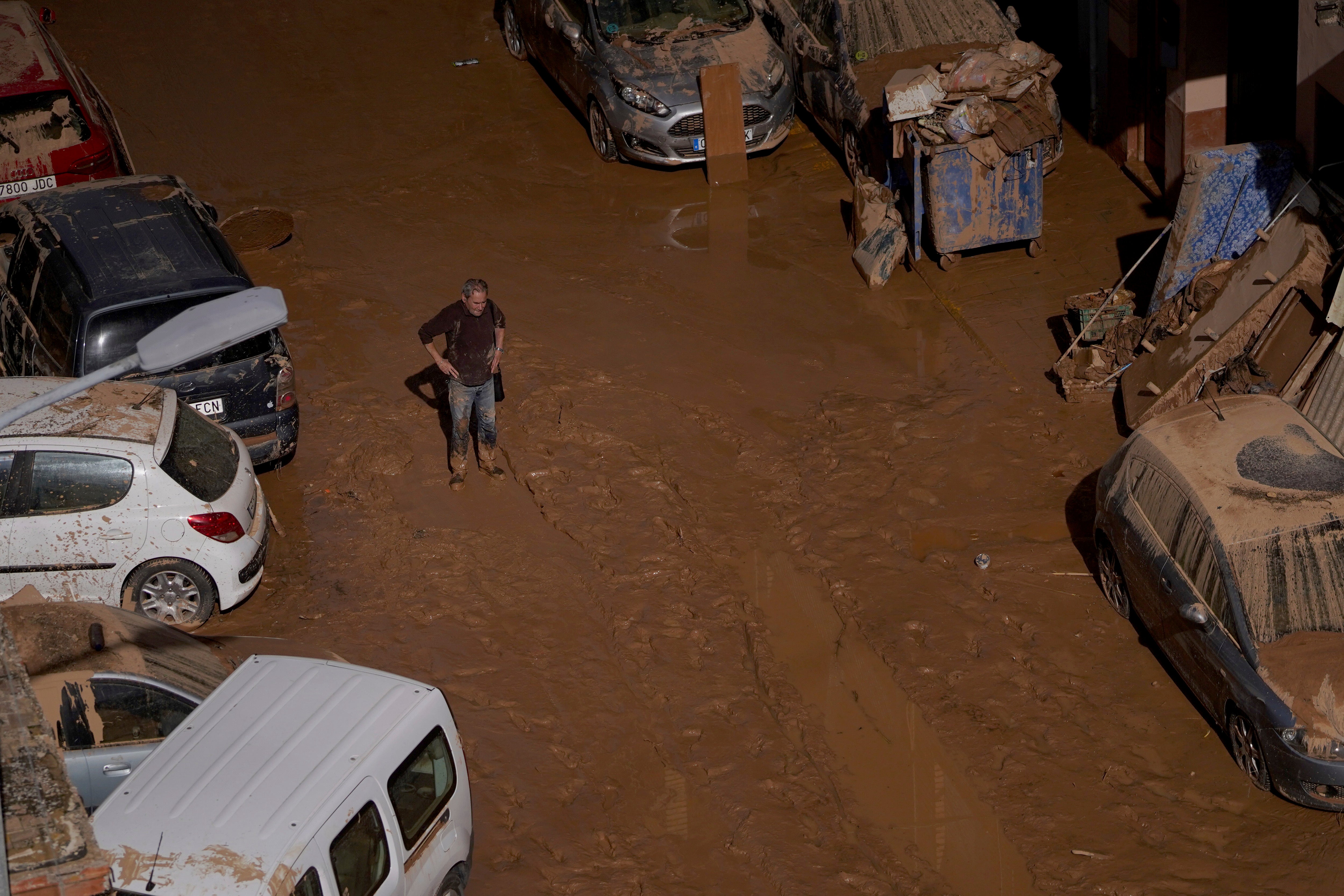 A man stands next to houses affected by floods in Valencia, Spain