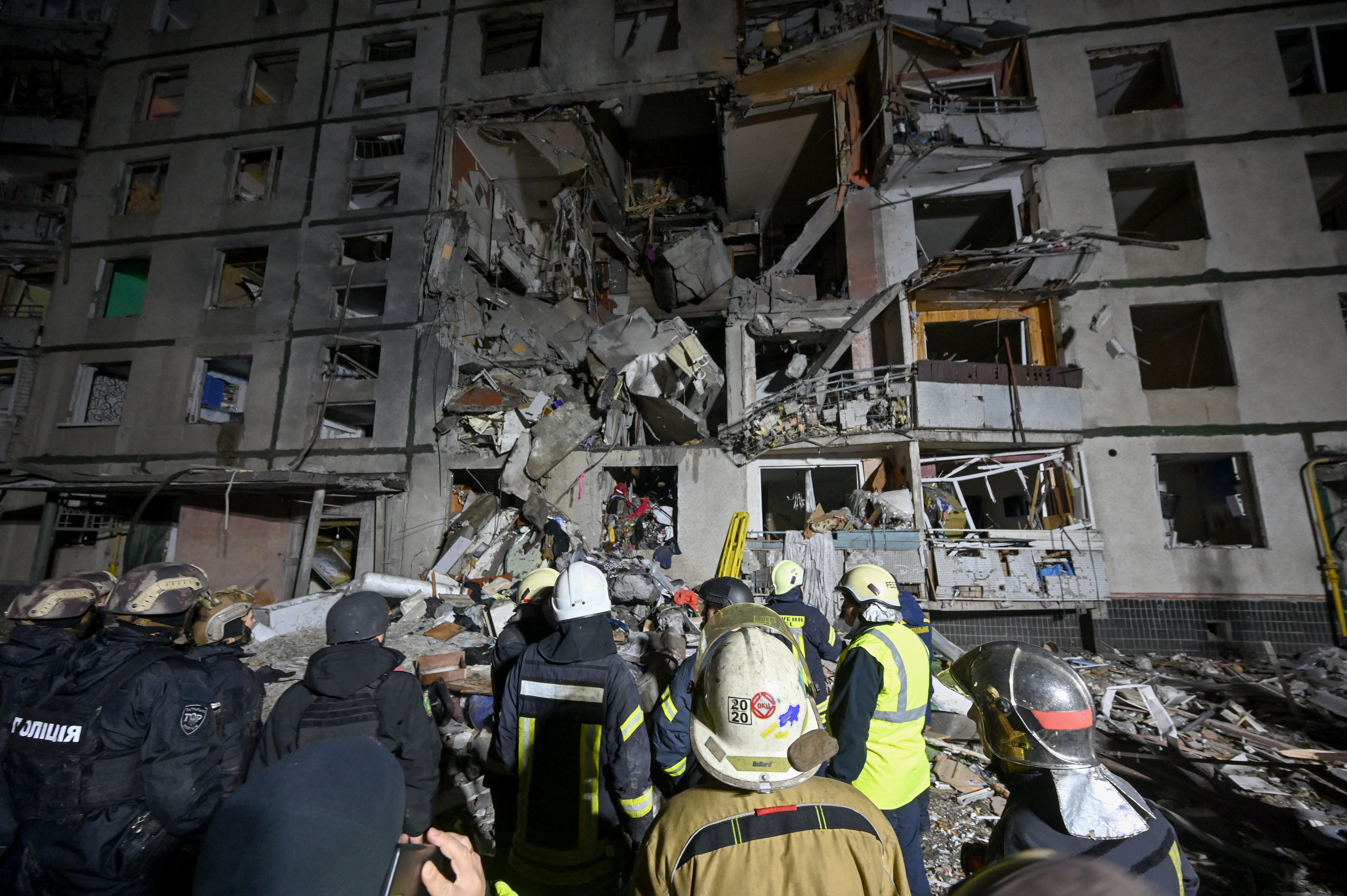 Rescuers work near an apartment building damaged in Kharkiv after a Russian guided-bomb strike