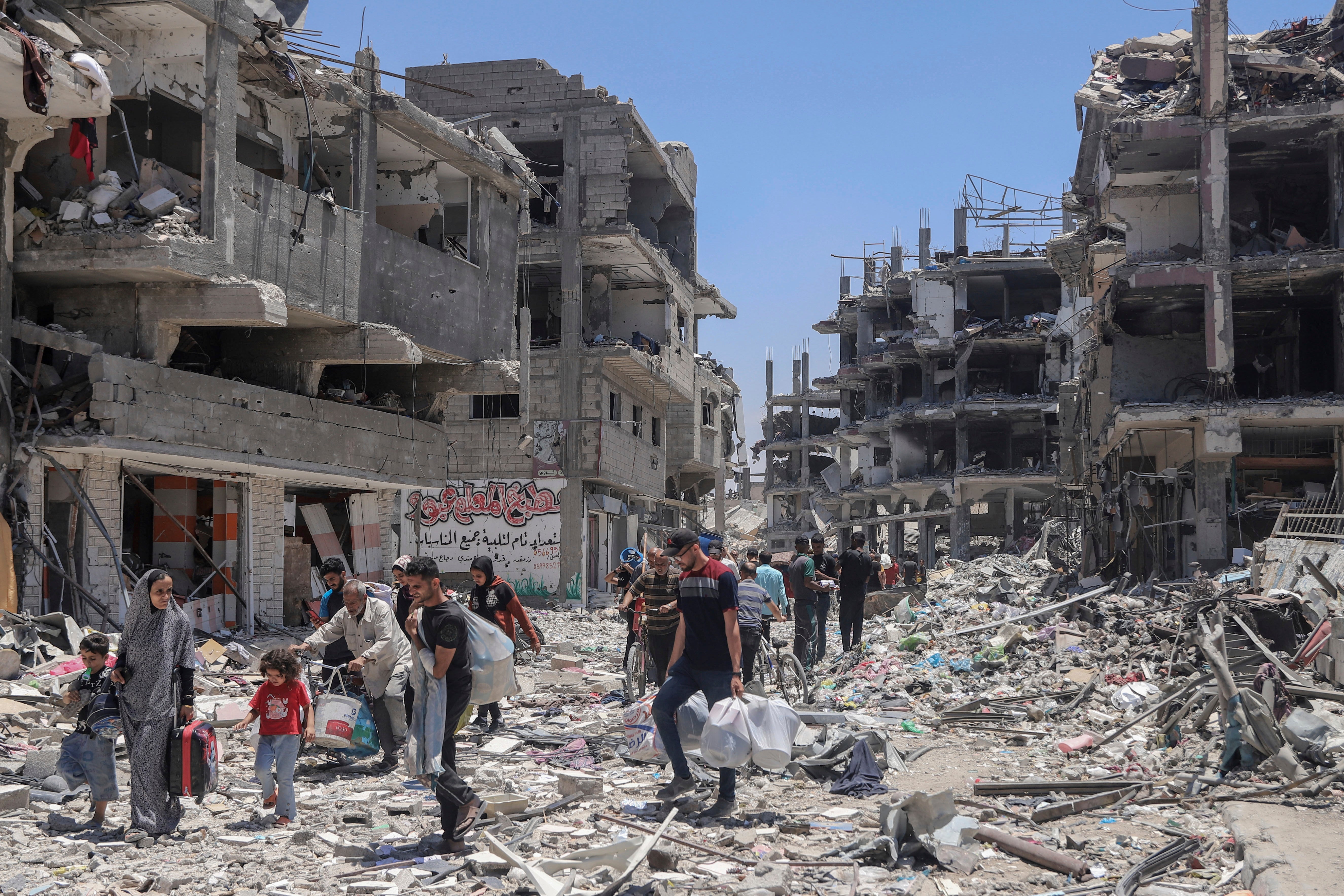 Palestinians walk through the destruction in the wake of an Israeli air and ground offensive in Jebaliya, northern Gaza Strip, on May 30, 2024.