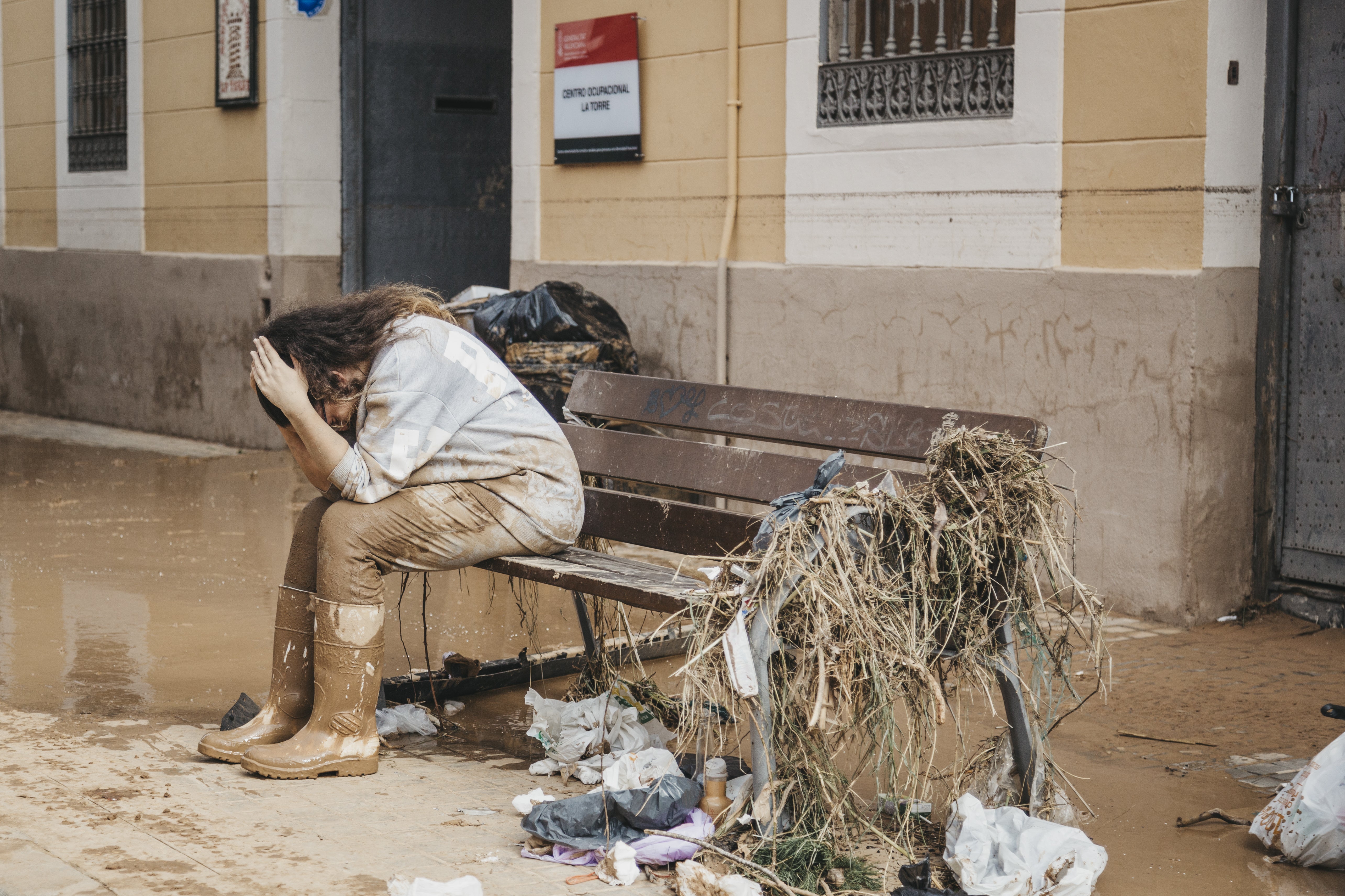 A young woman laments after seeing the state of her house in La Torre, Valencia, Spain