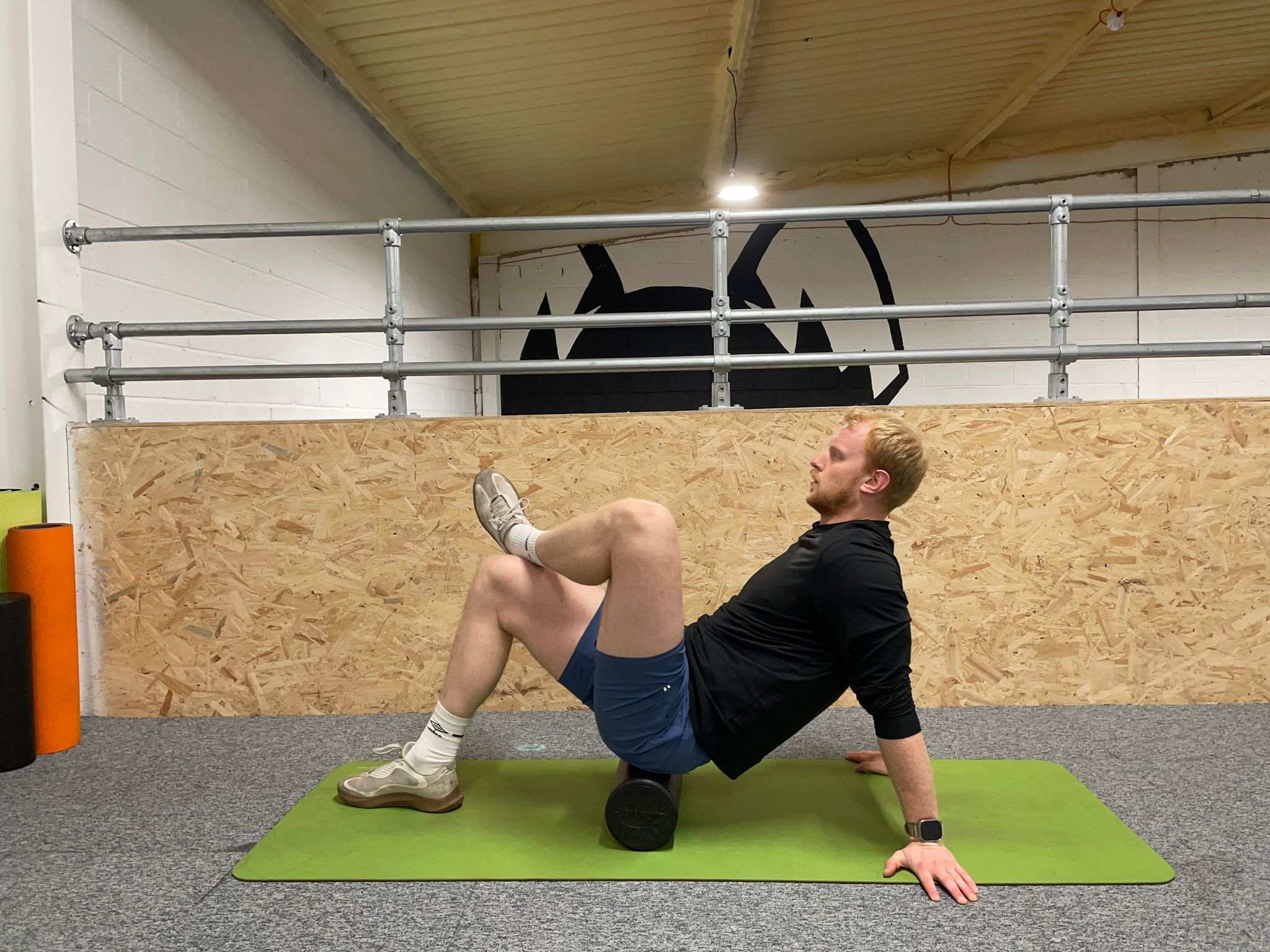 Demonstrating how to use a foam roller to soothe muscle soreness around the glutes