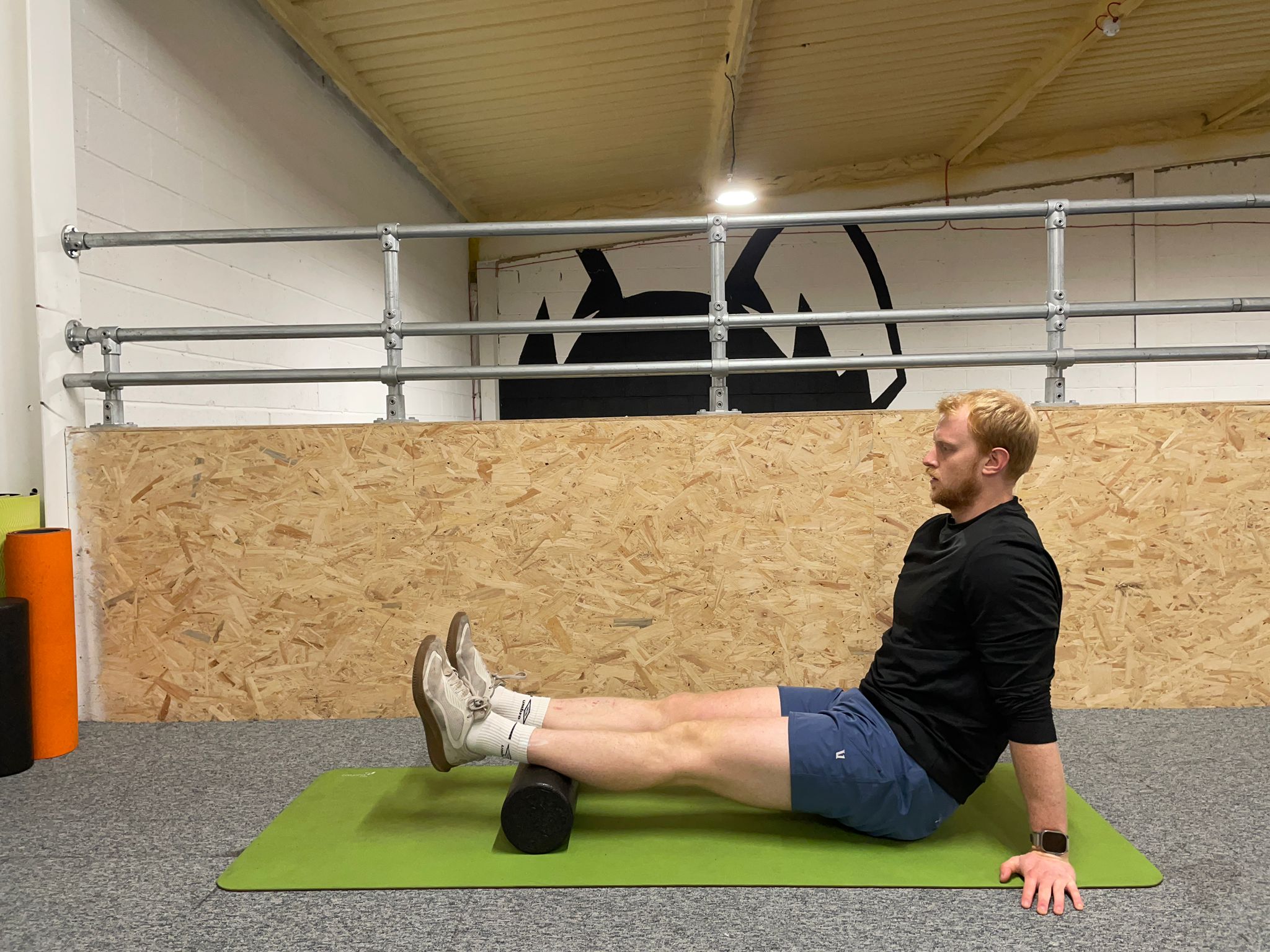 Demonstrating how to use a foam roller to soothe muscle soreness around the calf and Achilles tendon