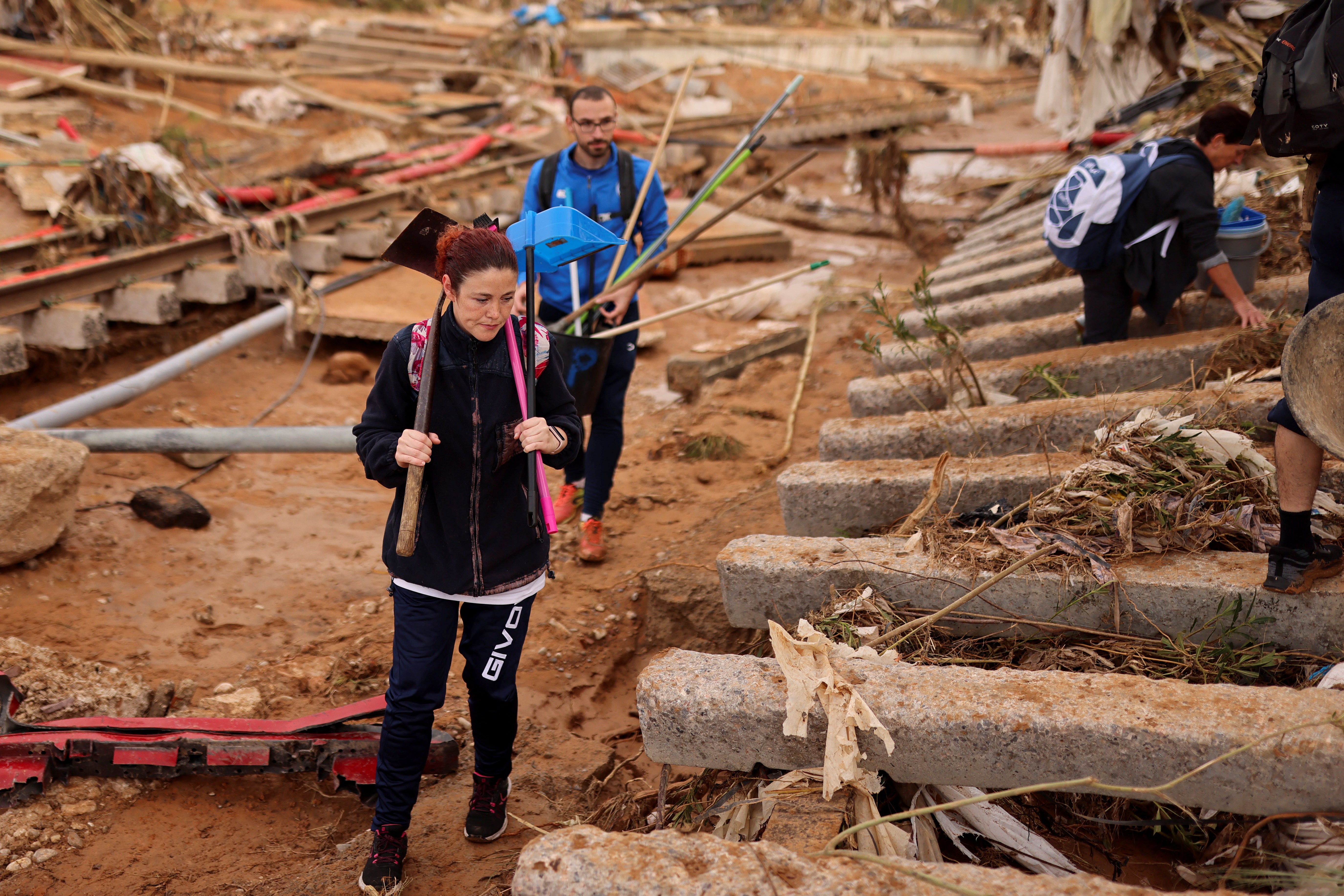 People carry supplies to help places affected by heavy rains that caused floods, in Paiporta, near Valencia, Spain