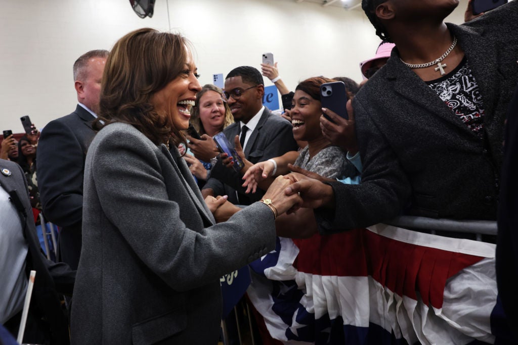 Kamala Harris greets supporters on the ropeline as she campaigns for president in Detroit