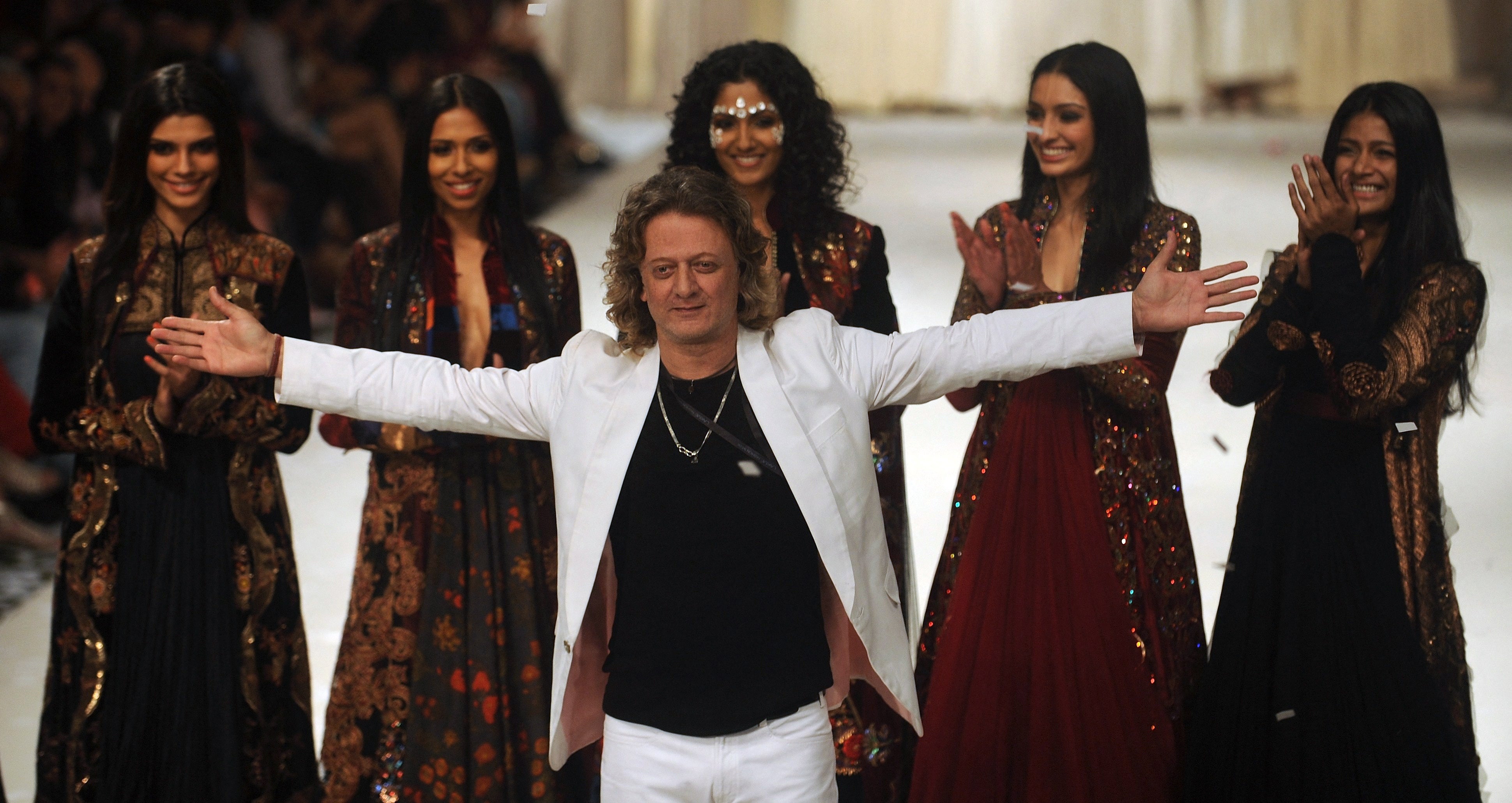 Indian designer Rohit Bal (C) poses with models during the grand finale of the Lakme Fashion Week (LFW) summer resort 2012 in Mumbai on March 6, 2012