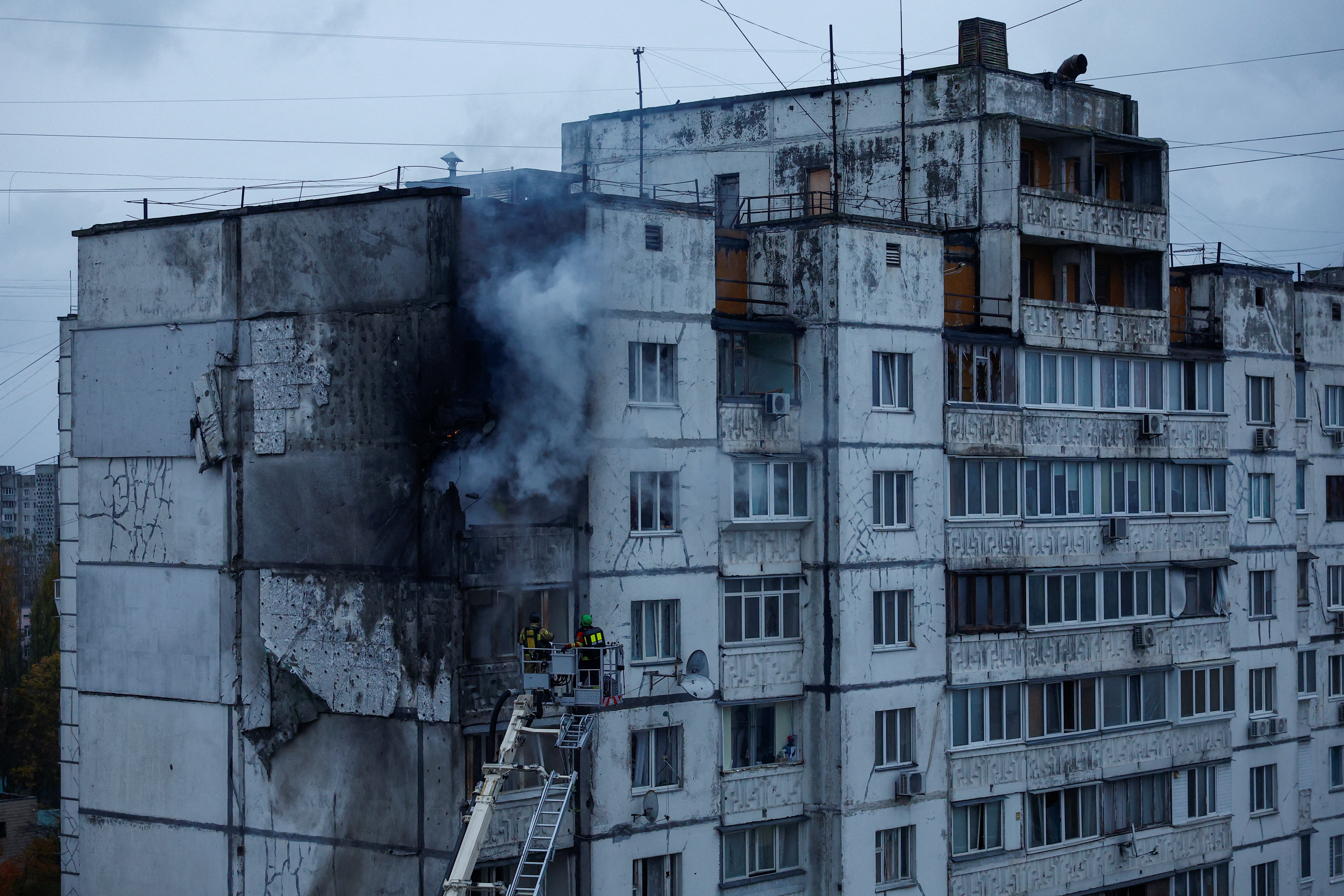 Firefighters work at a site of a Kyiv apartment building damaged by a Russian drone strike