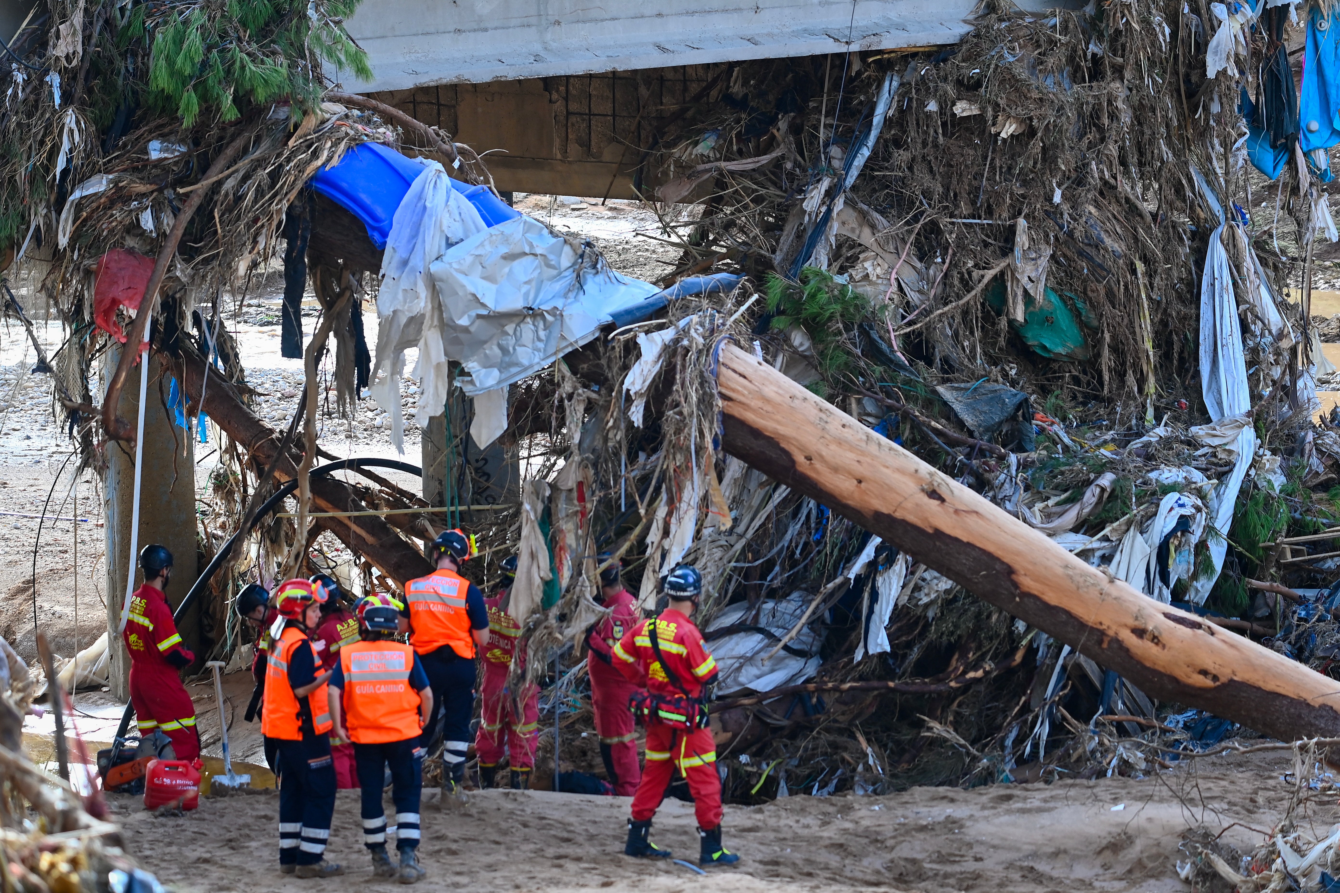 Portuguese firefighters and civil protection members search for victims in debris along a river in the town of Paiporta in the Valencia region