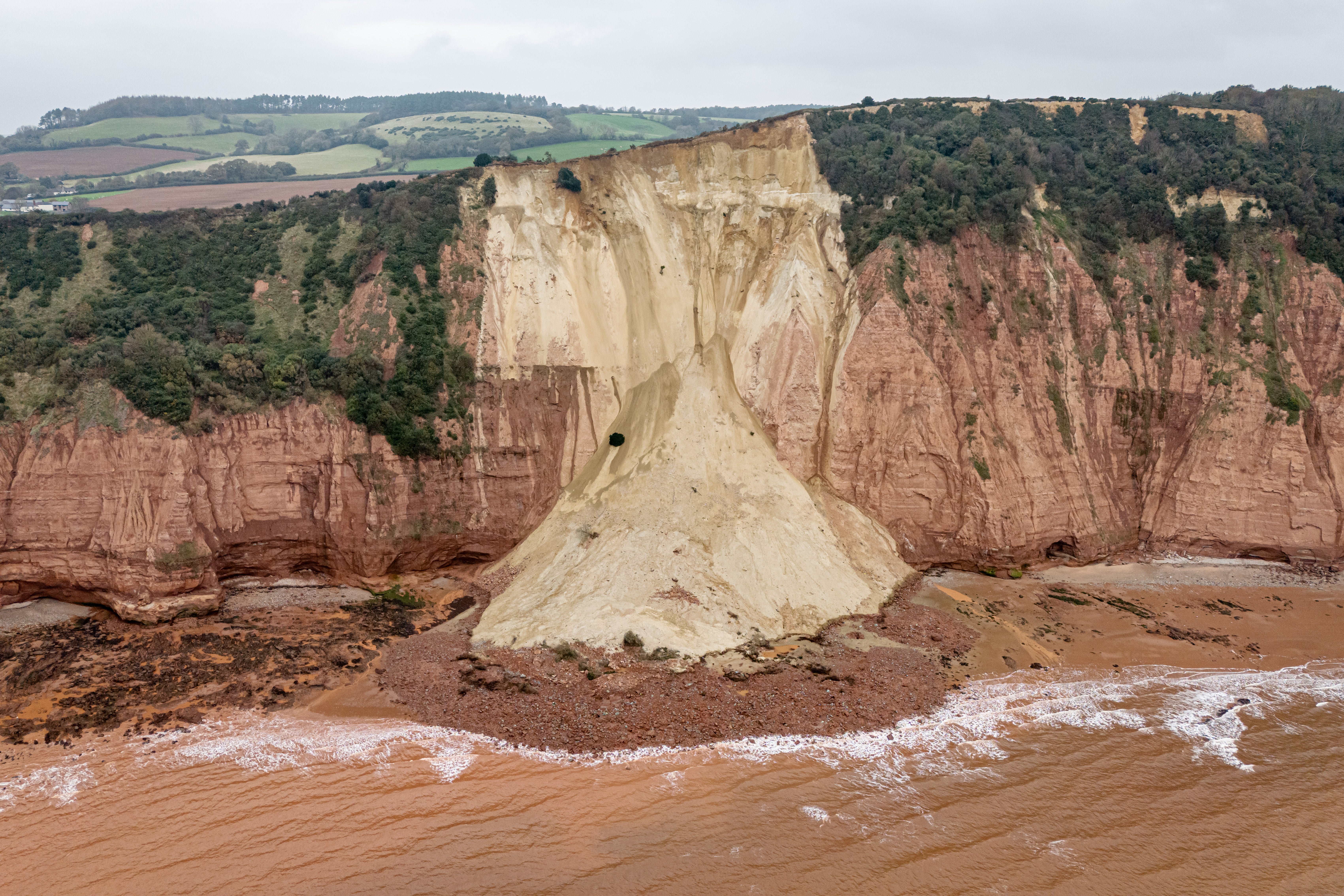 The cottage teeters just above a large rockfall between Sidmouth and Ladram Bay