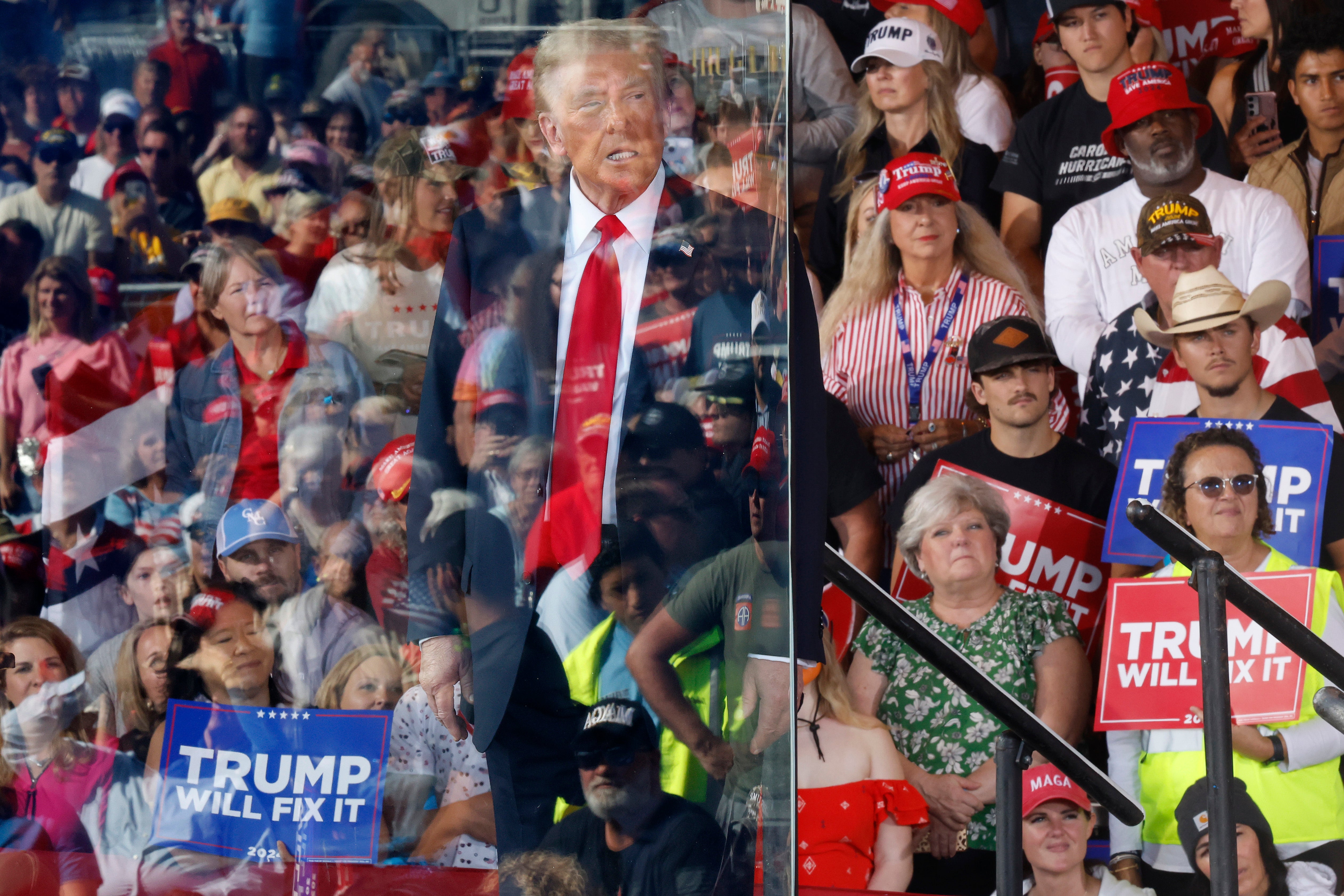 Trump stood behind a glass barrier at the rally