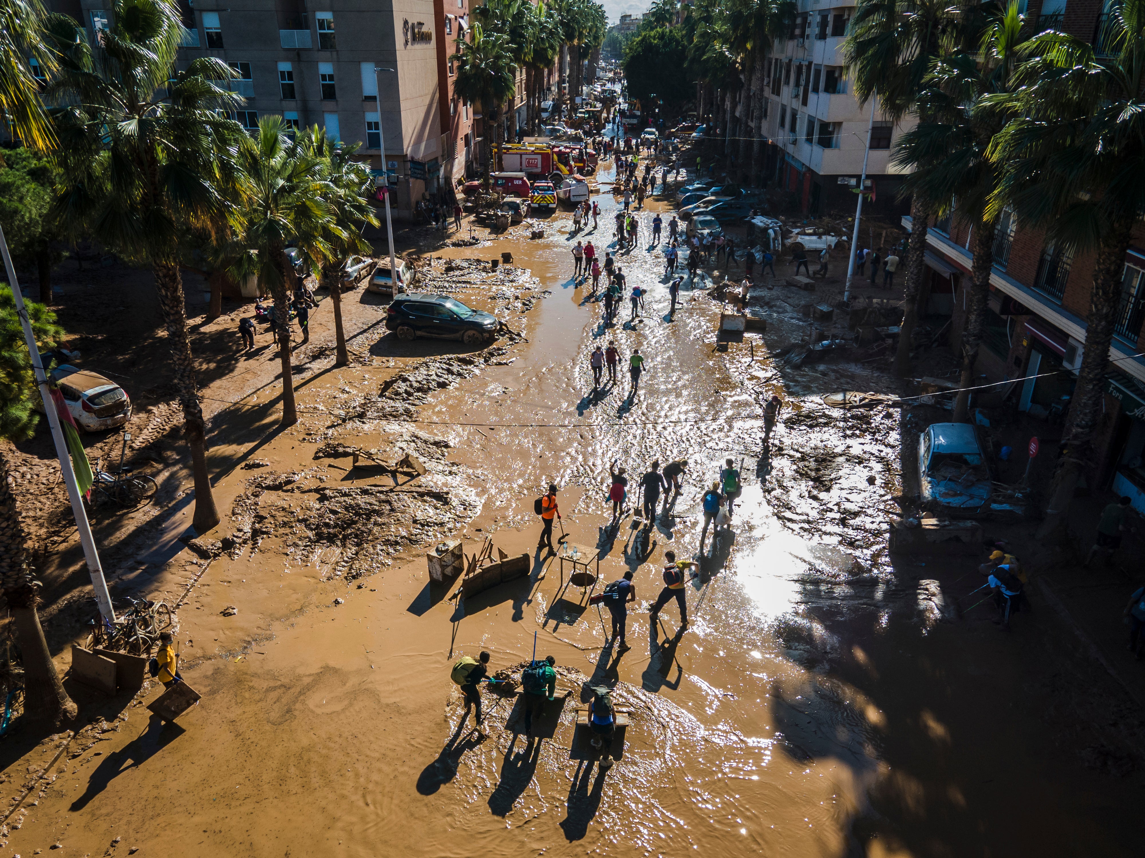 Volunteers and residents clean the mud four days after flash floods swept away everything in their path in Paiporta