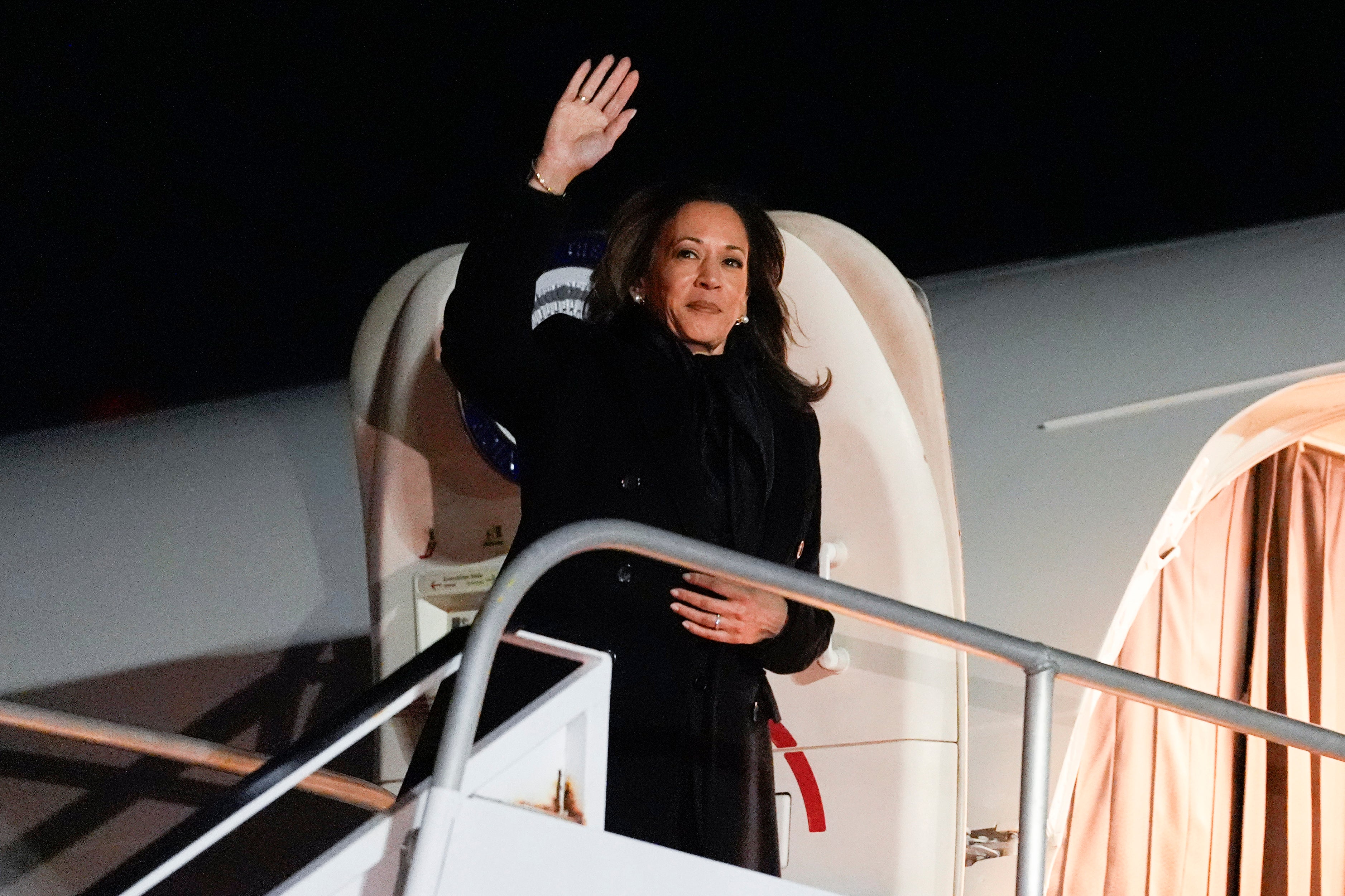 Democratic presidential nominee Vice President Kamala Harris waves as she boards Air Force Two at LaGuardia Airport