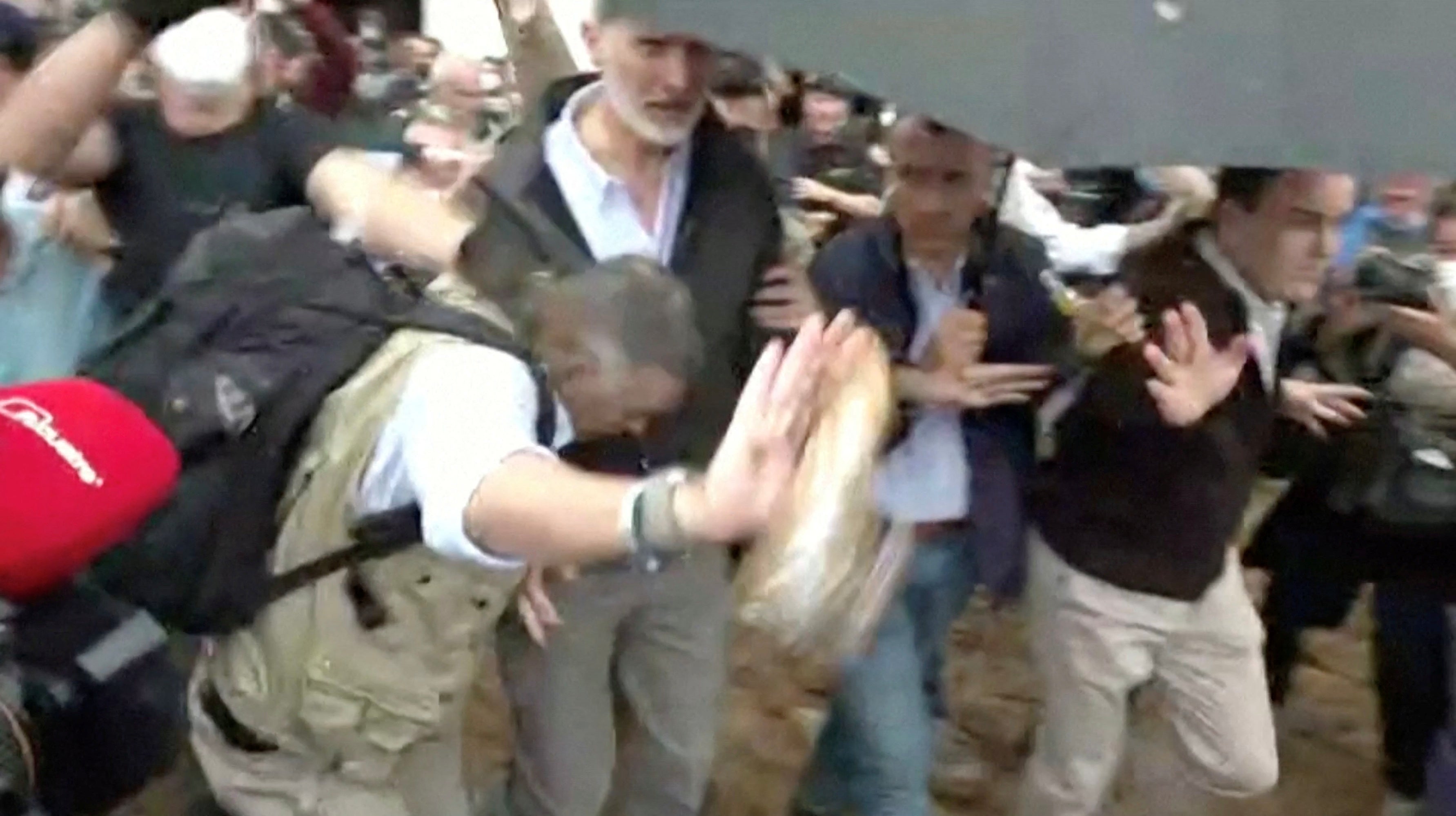 A piece of mud thrown at Spain's King Felipe is intercepted by a member of his security