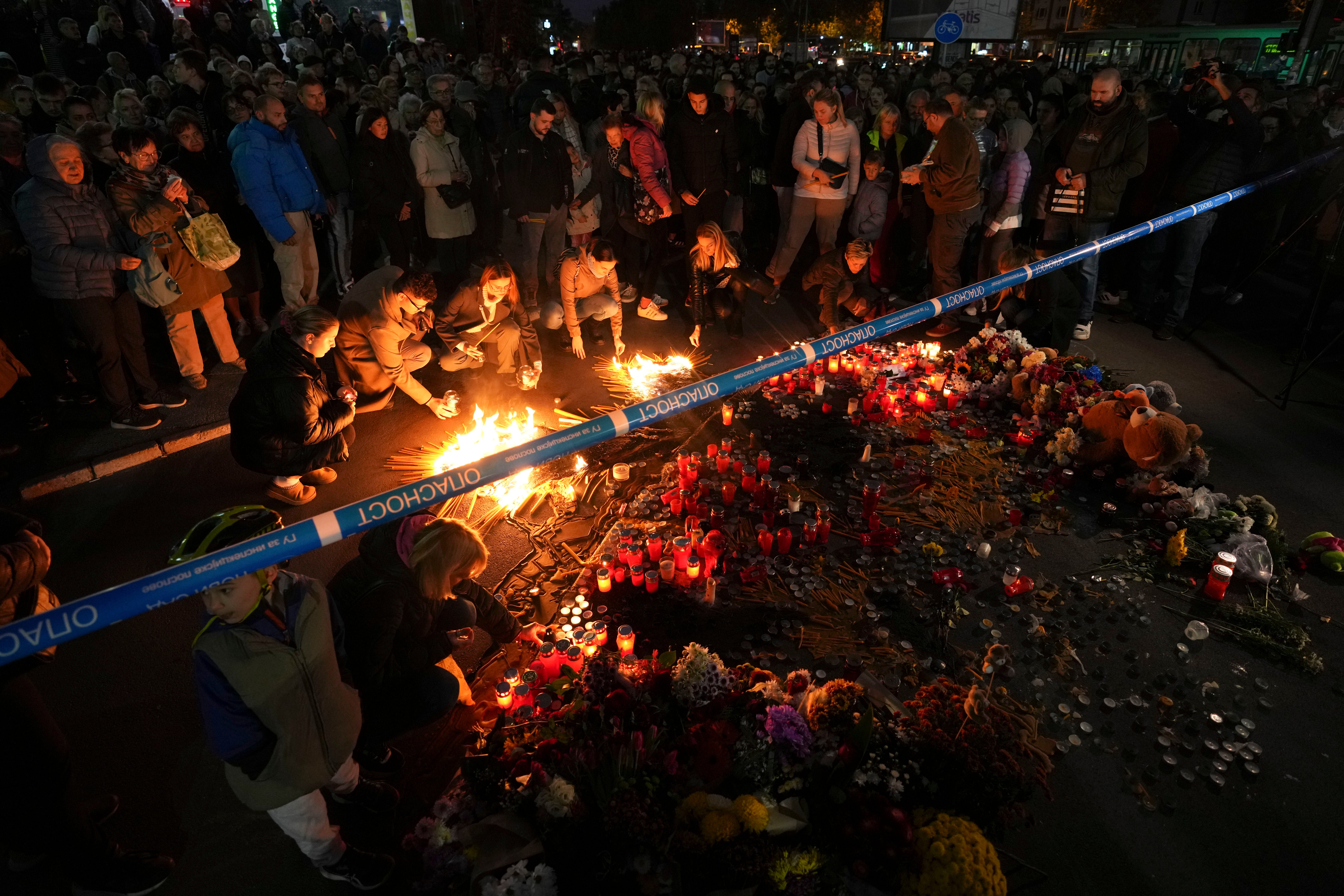 People light candles for the victims of an outdoor roof collapse at a train station in Novi Sad, Serbia