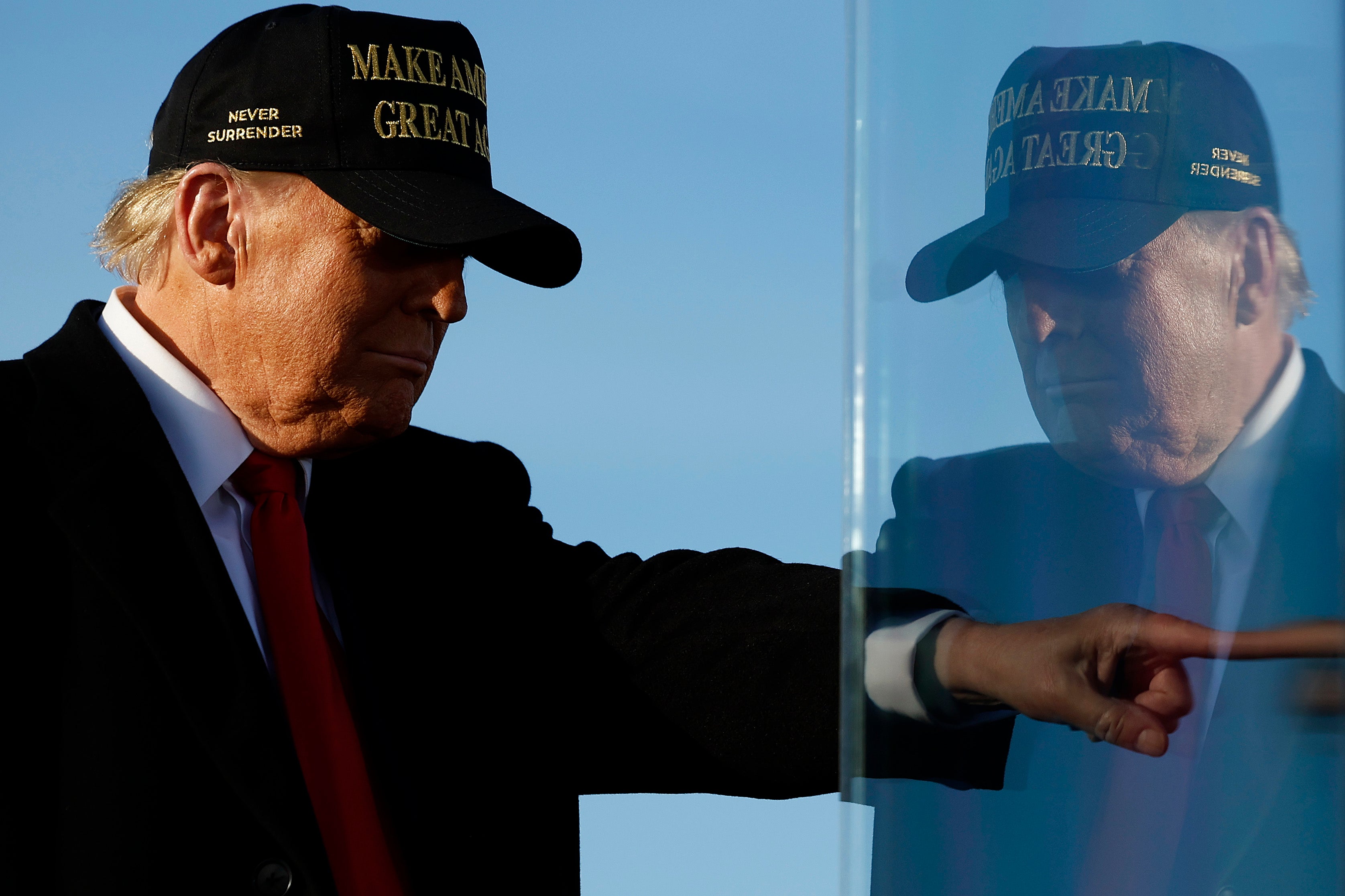 Republican presidential nominee, former President Donald Trump is reflected in the bullet-resistant safety glass that surrounds him during a campaign rally at Kinston Regional Jetport on November 03, 2024 in Kinston, North Carolina