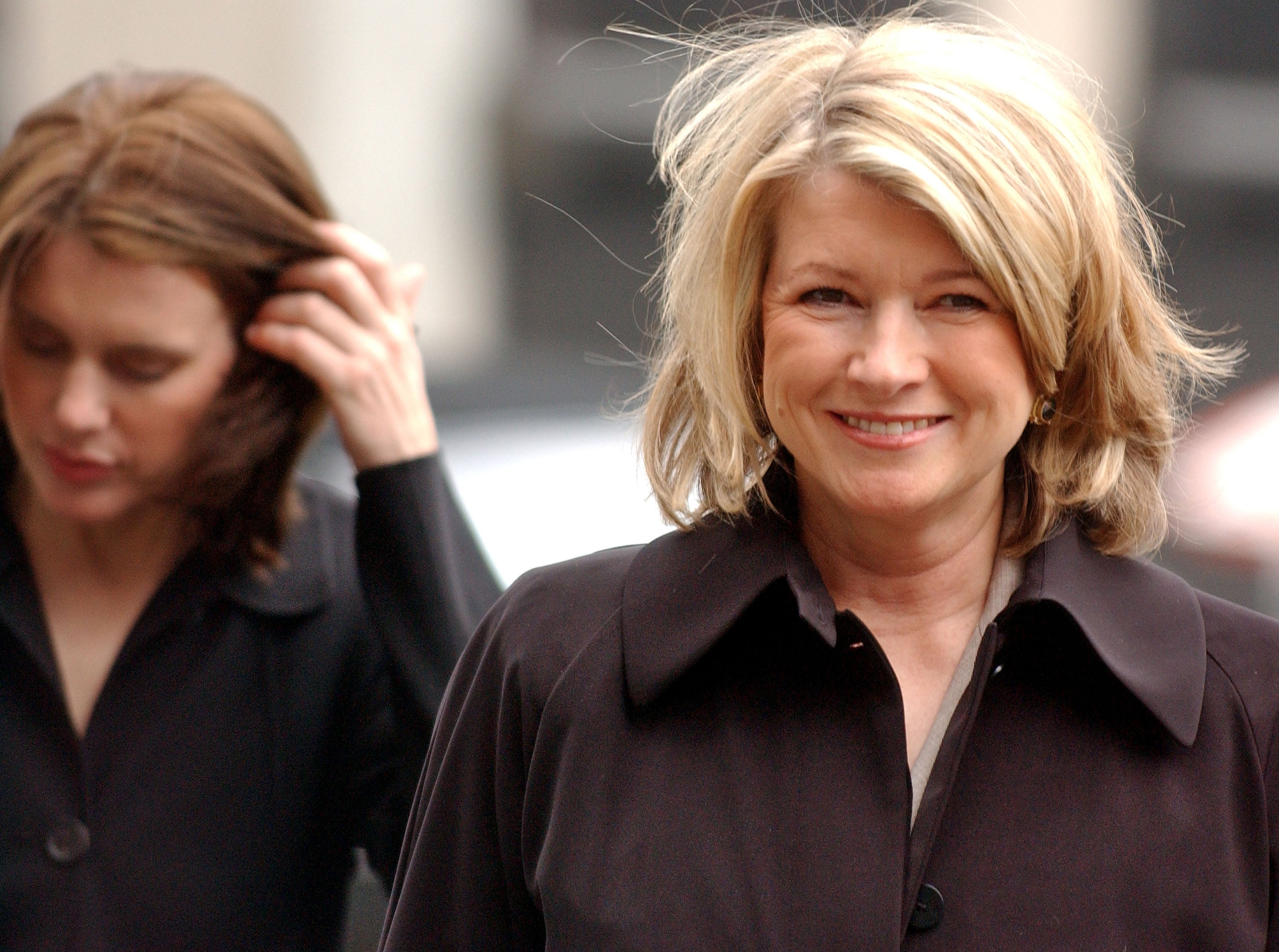 Martha Stewart (R) smiles as her daughter Alexis Stewart (L) pushes her hair back as they arrive at federal court March 2, 2004 in New York City