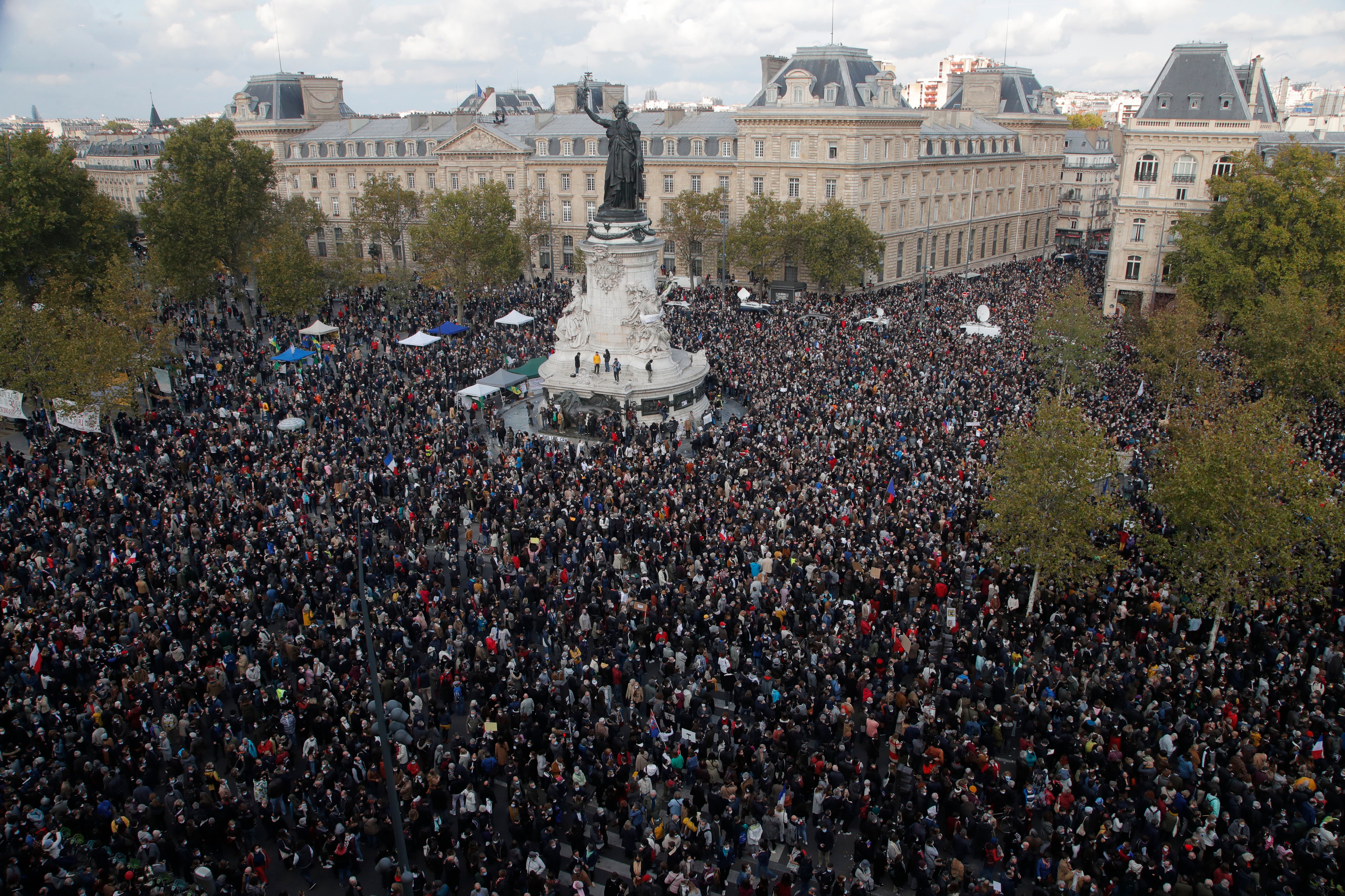 Hundreds of people gather on Republique square during a demonstration Sunday Oct. 18, 2020 in Paris, in support of freedom of speech and to pay tribute to French history teacher Samuel Paty