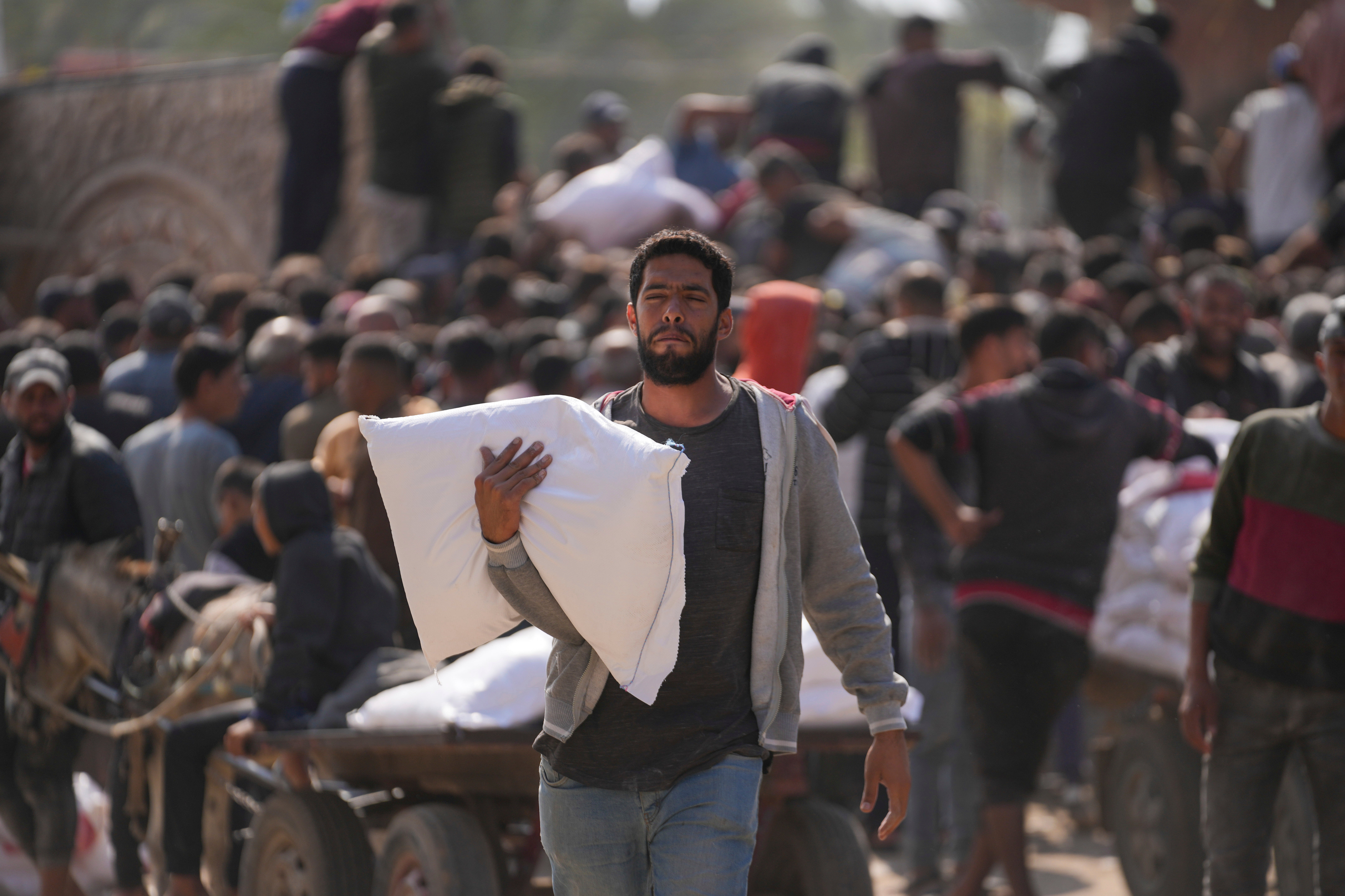 Palestinians gather to receive bags of flour distributed by Unrwa in Deir al Balah, central Gaza, on 2 November 2024