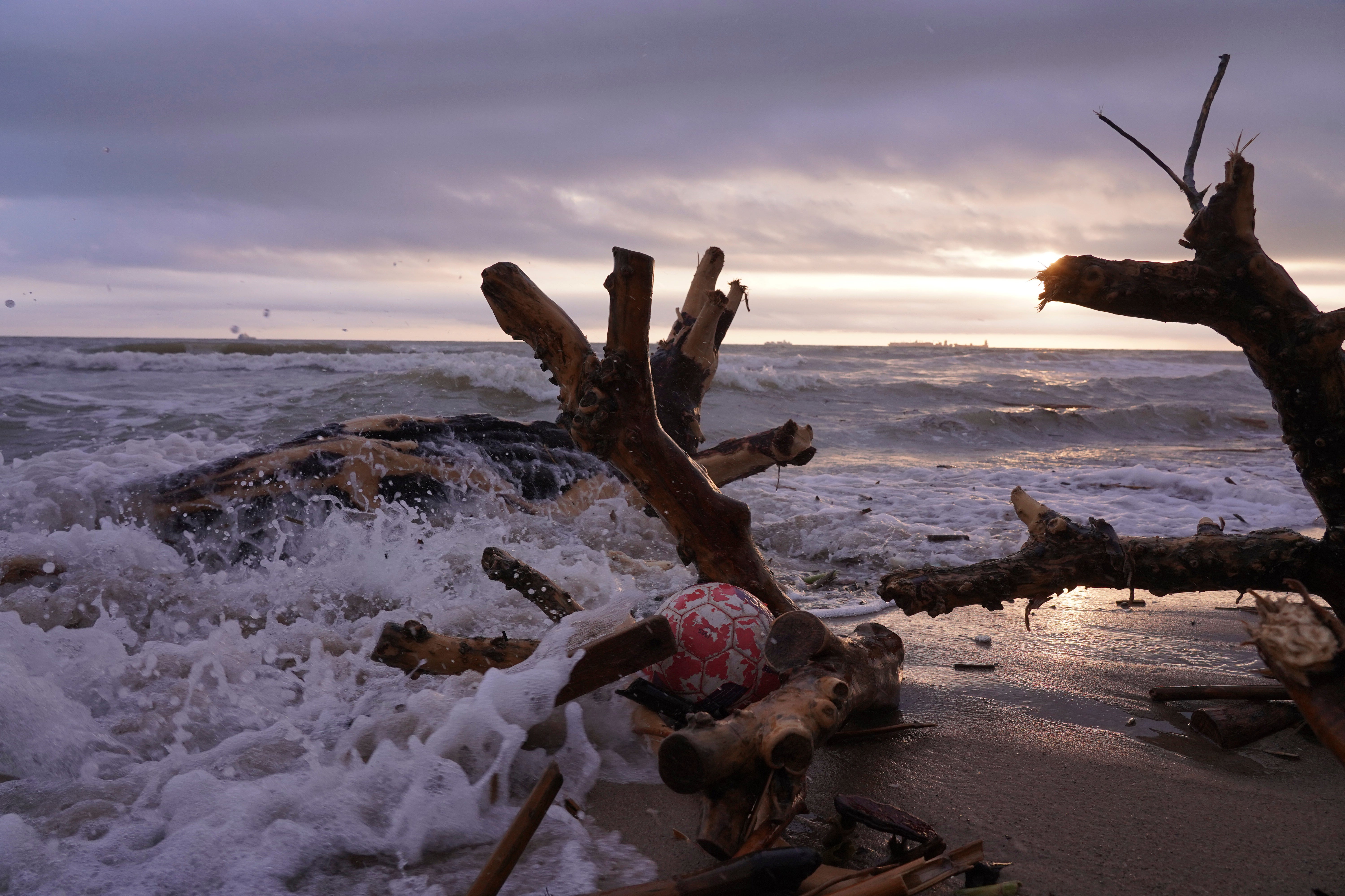 Waves crash over a soccer ball on the Pinedo beach as the search for bodies continues after floods in Valencia, Spain