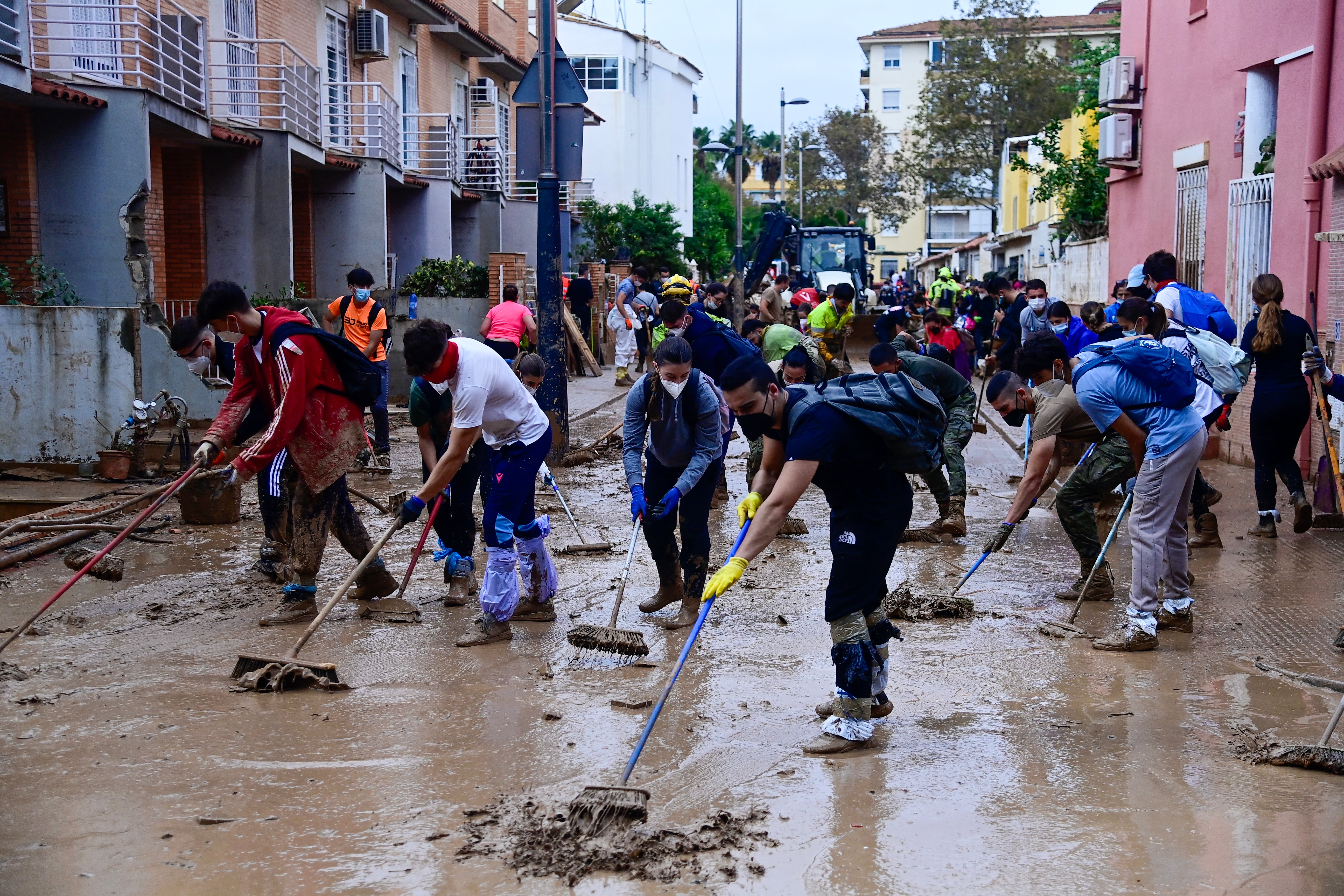 People clear mud from a street in Alfafar, in the region of Valencia, eastern Spain