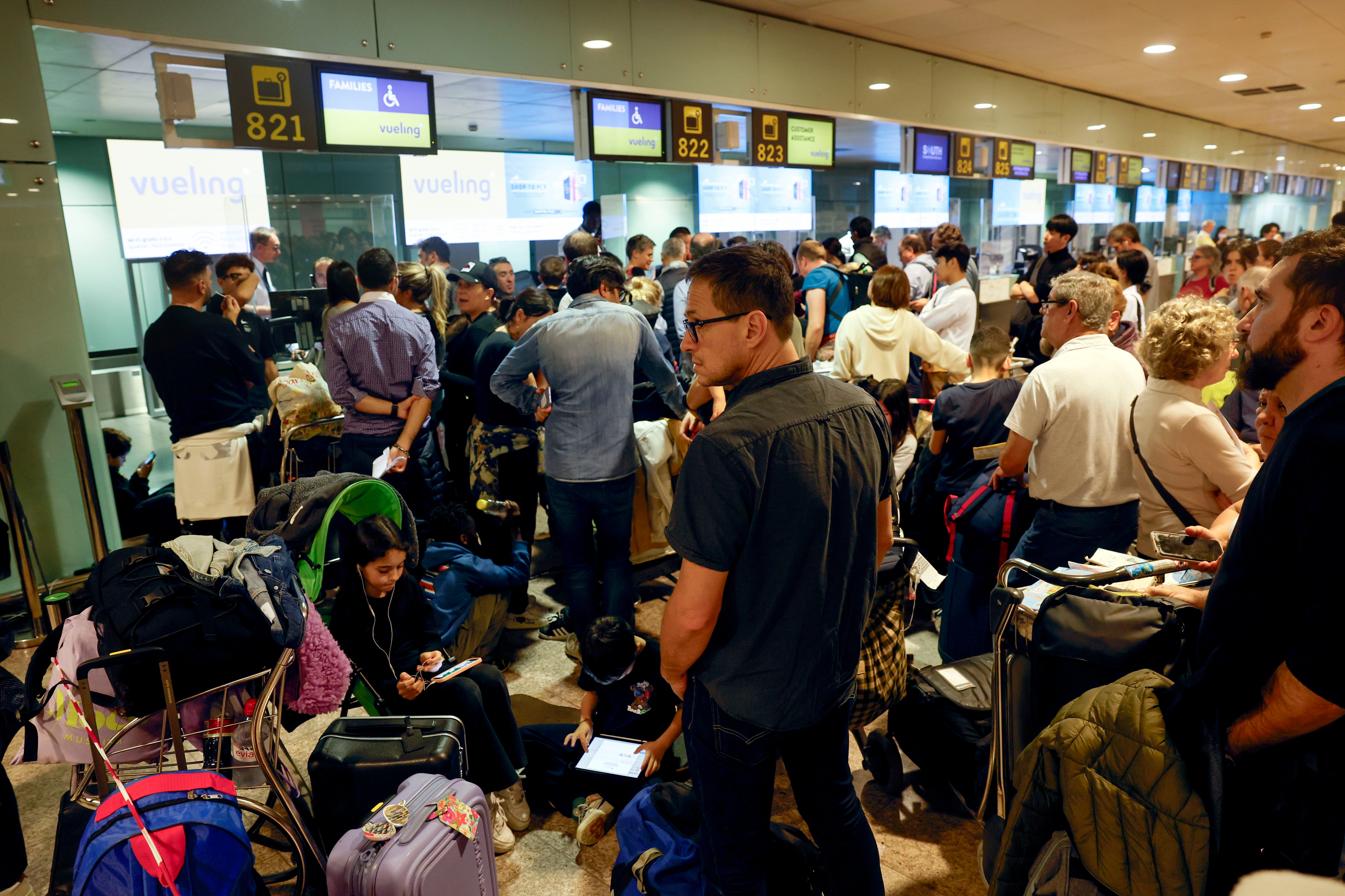 Passengers wait at El Prat Airport after several flights were canceled due to heavy rains, in Barcelona, Catalonia, Spain