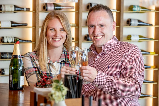 <p>Alison Coke and Luke Harris toast the win from a scratch card purchased from a Co-op store in Canterbury in Kent </p>