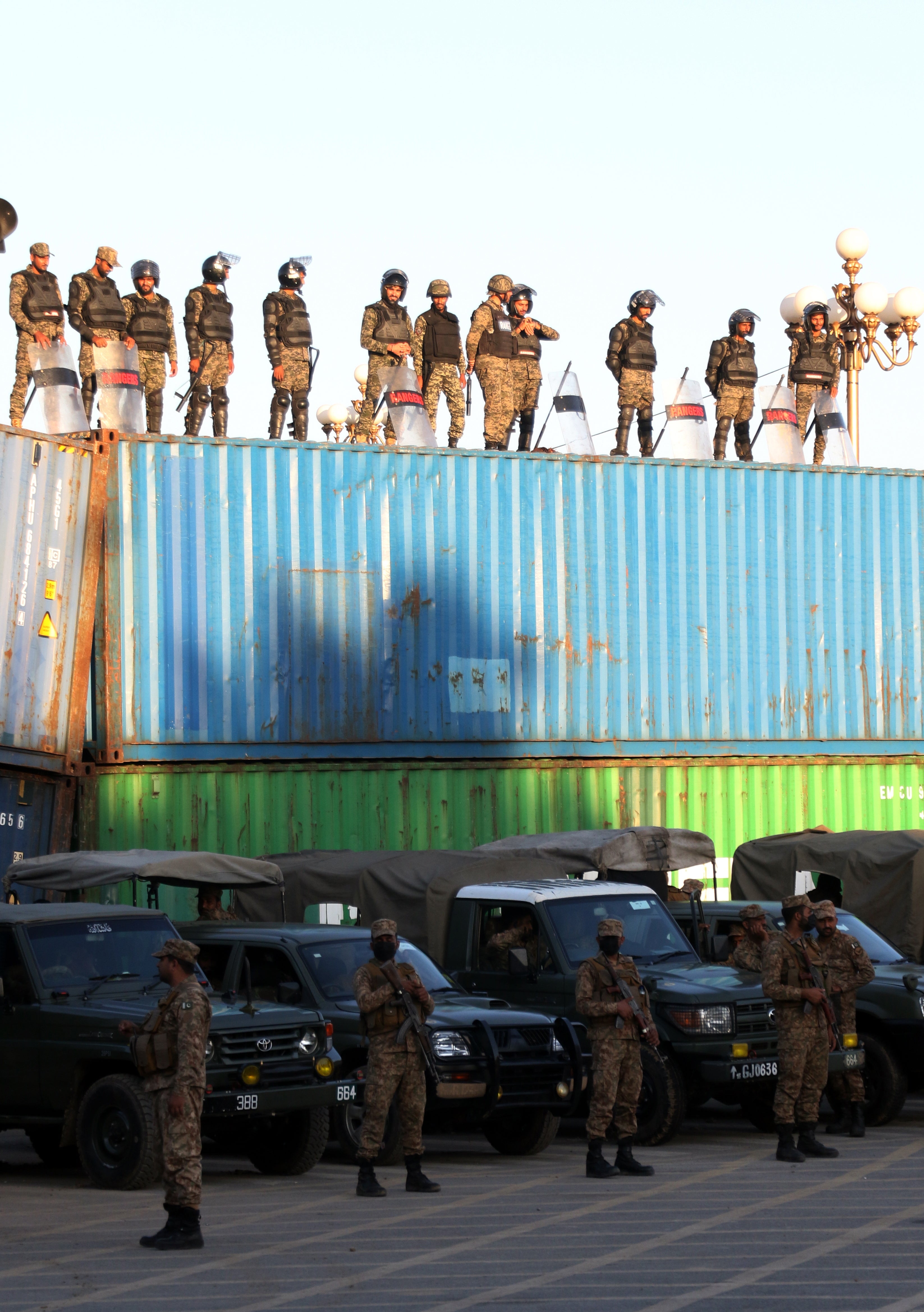 Pakistani Army and security officials stand guard as the opposition party Pakistan Tehrik-e-Insaft (PTI) members stage protest for the release of Imran Khan