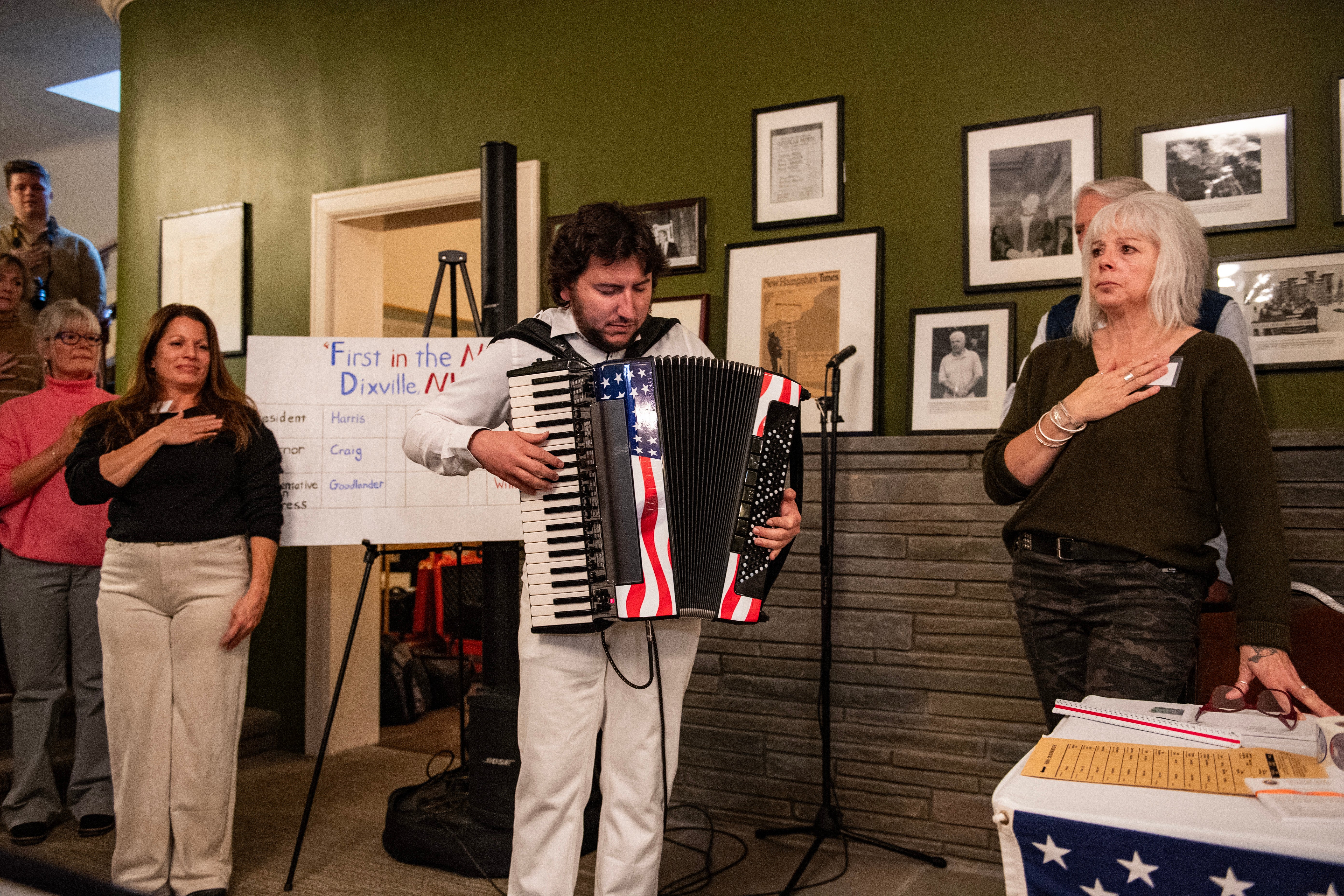 A musician plays the National Anthem as the residents of Dixville Notch prepare to cast their ballots in the US election at midnight in the living room of the Tillotson House at the Balsams Grand Resort, marking the first votes in the US election