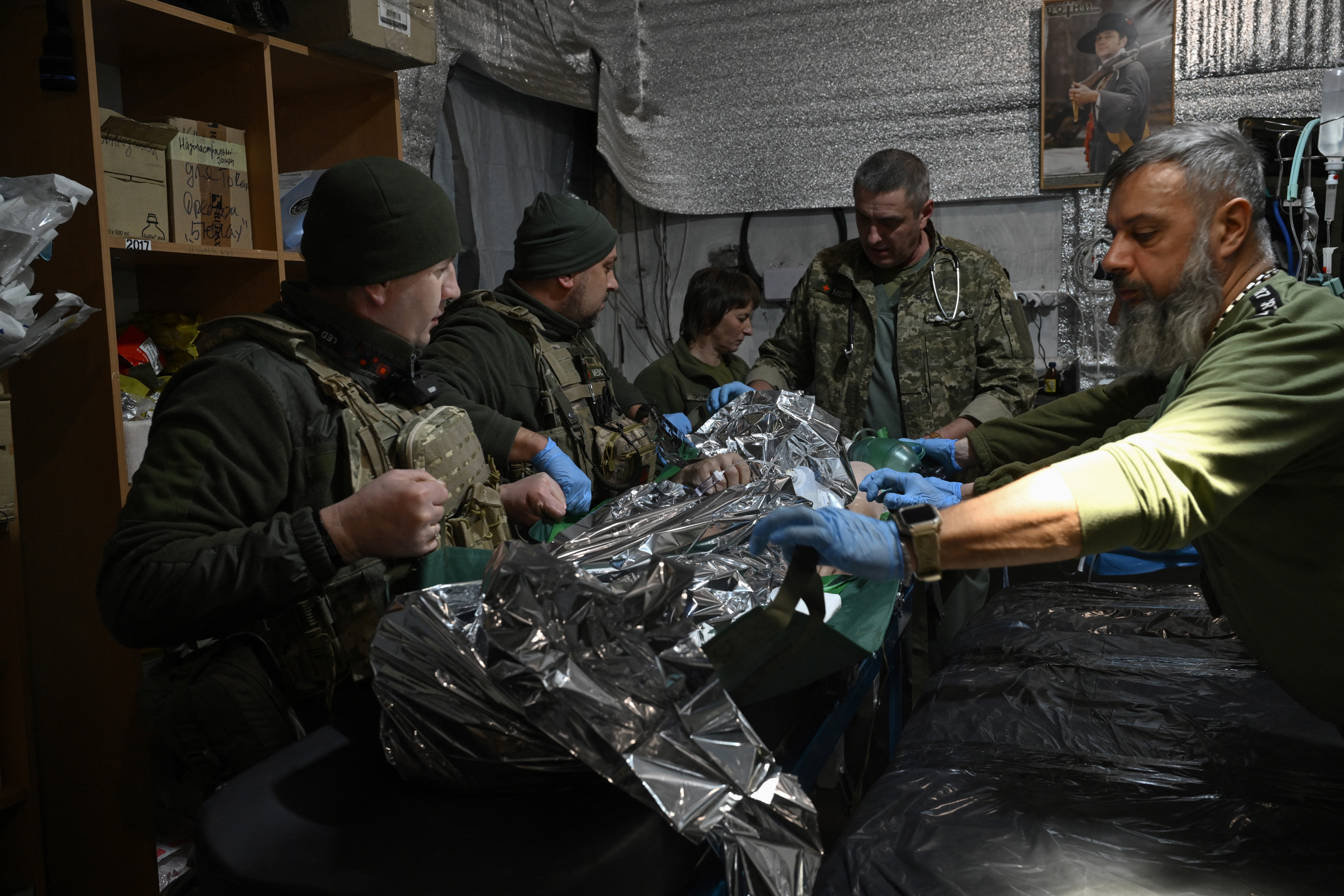 Ukraine military medics of the 5th Assault Brigade treat a wounded Ukrainian serviceman at a stabilization point in an undisclosed location near the front line in Donetsk region