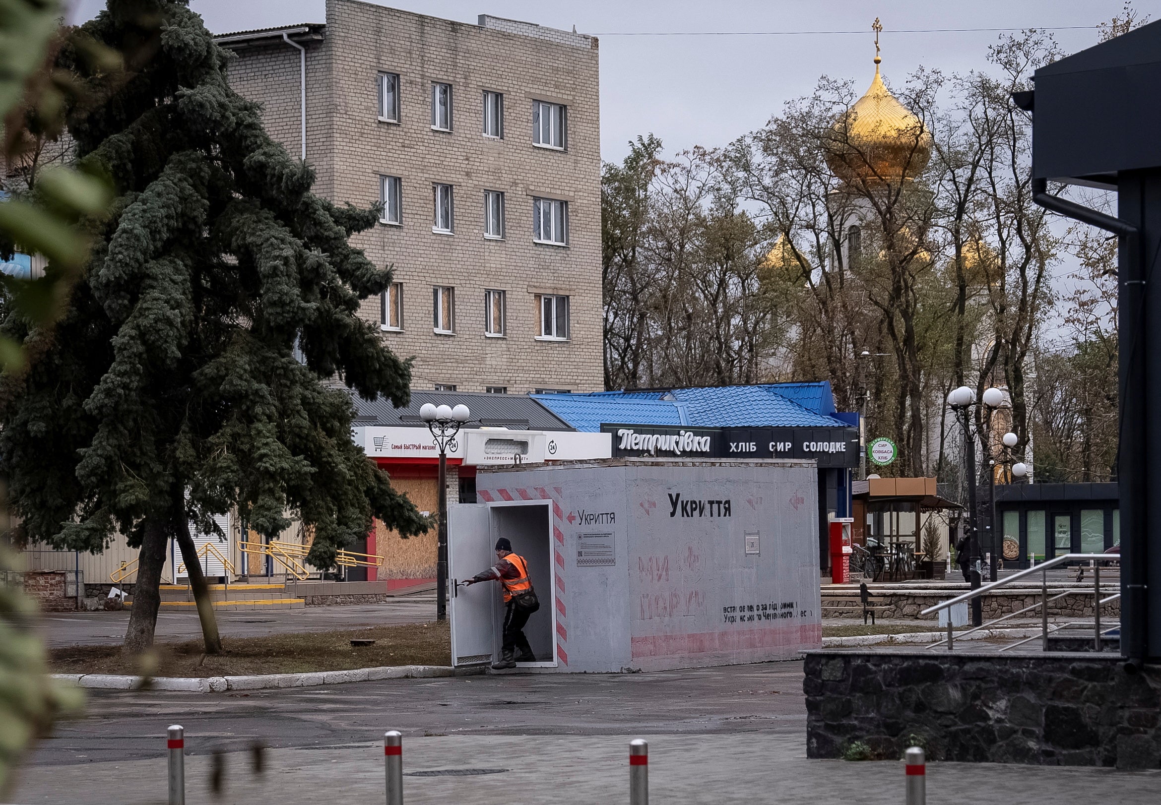 A resident enters a reinforced concrete bomb shelter installed in a street in the town of Pokrovsk