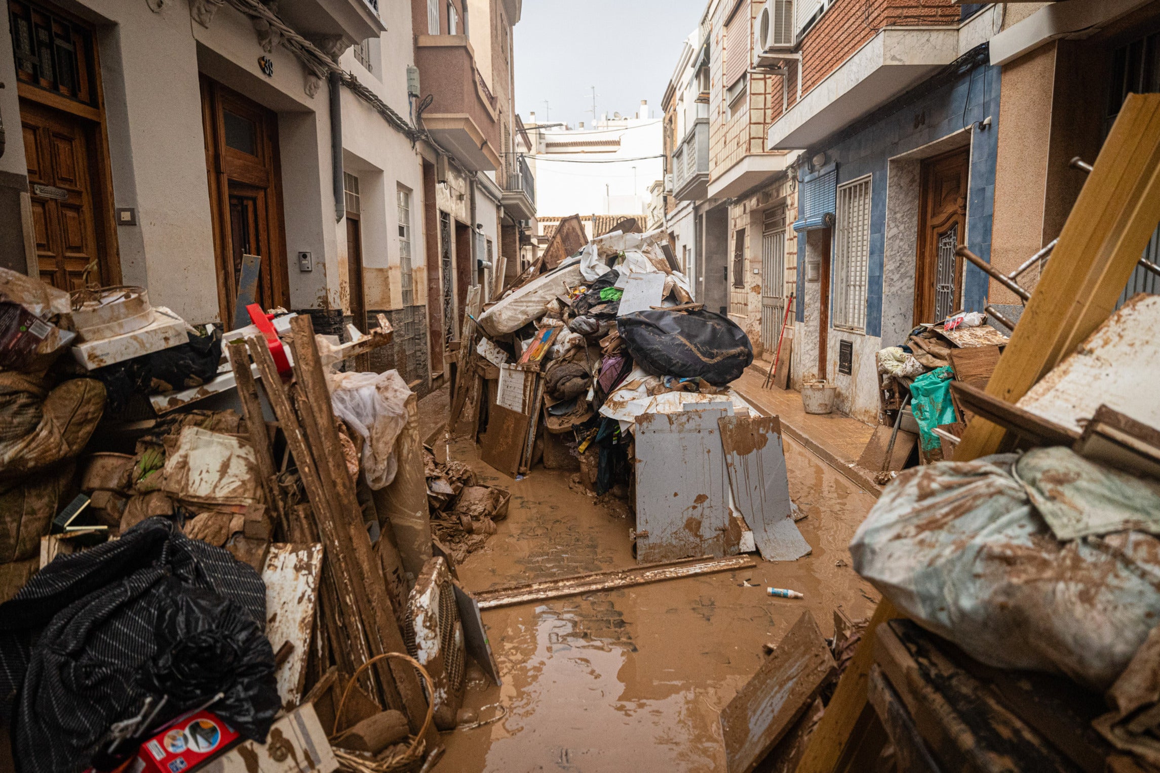 Furniture, debris, and broken items that people have been placing in the streets to clear out the interiors of their muddy homes