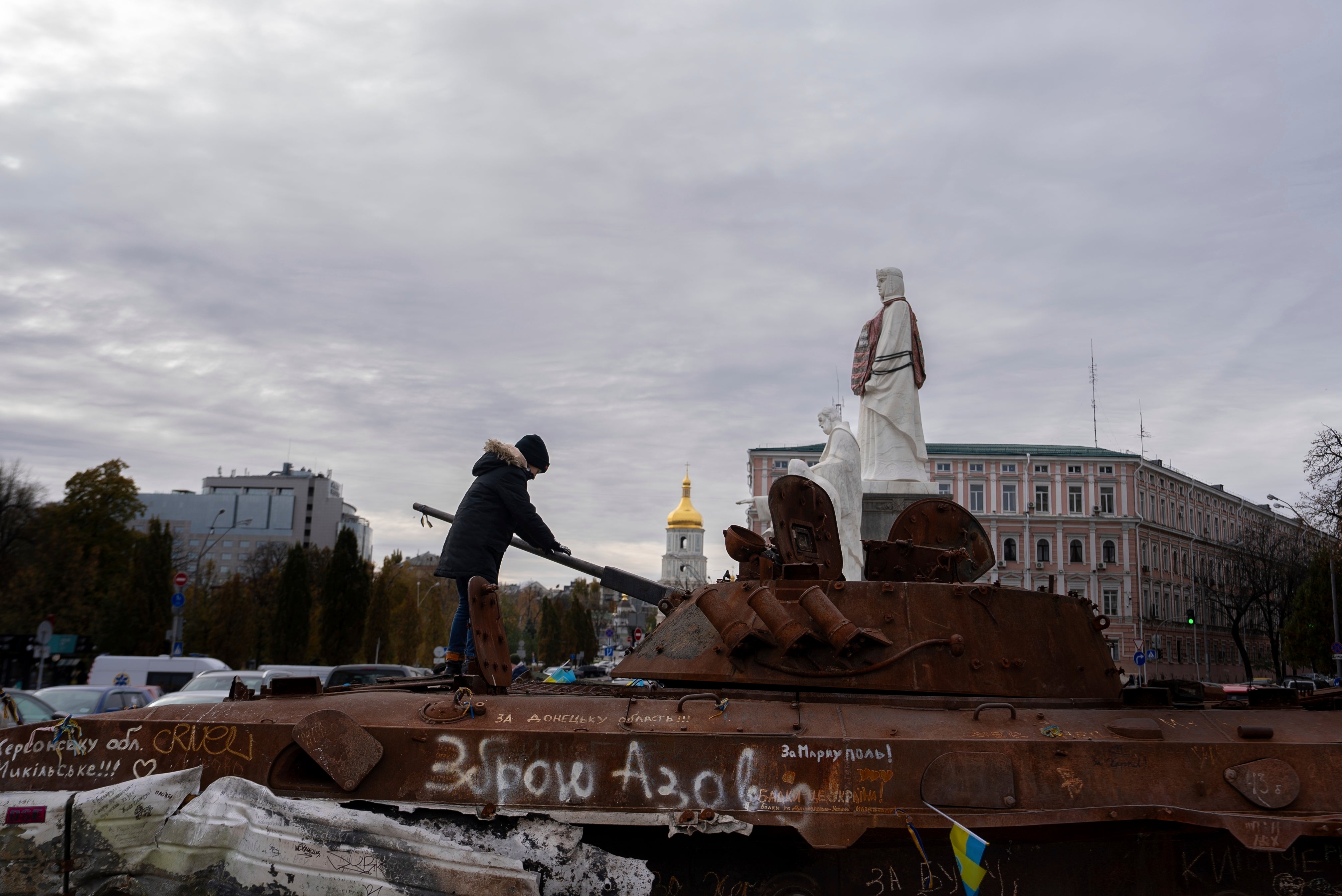 A boy stands on Russian burned APC in central Kyiv, Ukraine