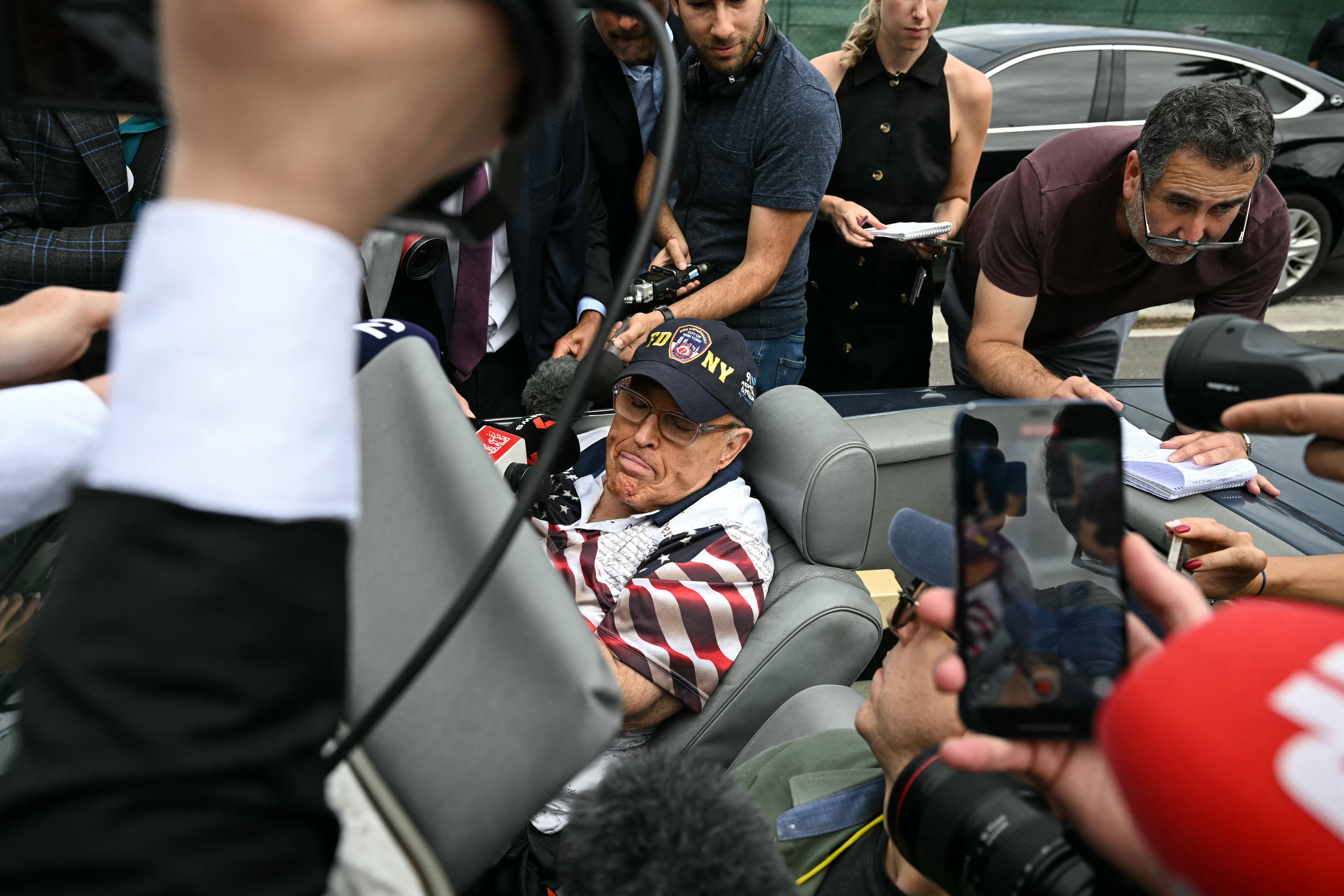 Rudy Giuliani arrives at Donald Trump’s polling place on Election Day in Florida on November 5. He is seated in a Mercedes Benz that a judge ordered him to hand over to a pair of election workers he defamed as they try to collection their $150 million verdict.