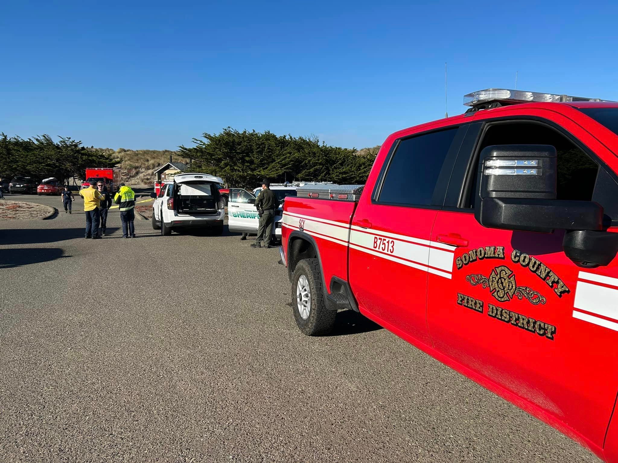 A Sonoma County Fire District truck is seen in the foreground, and cars and members of the county Sheriff’s Office are in the background. The Sheriff’s Office confirmed the deaths of at least two people in separate incidents after boats capsized off the California coast.