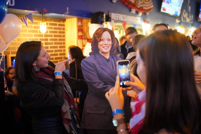 People pose for photos with a cardboard cutout of Kamala Harris at the Democrats Abroad US election watching event in central London. Picture date: Tuesday November 5, 2024 (PA)