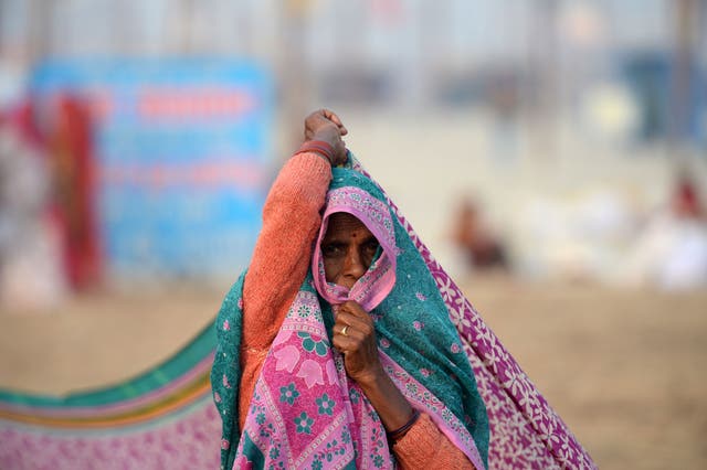 <p>An Indian woman dries her sari after taking a dip at Sangam during the Magh Mela festival in Allahabad on January 9, 2018</p>