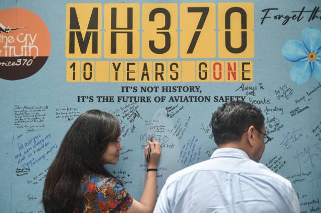 <p>A woman writes a message during an event held by relatives of the passengers and supporters to mark the 10th year since the Malaysia Airlines flight MH370 carrying 239 people disappeared from radar screens on 8 March 2014 </p>