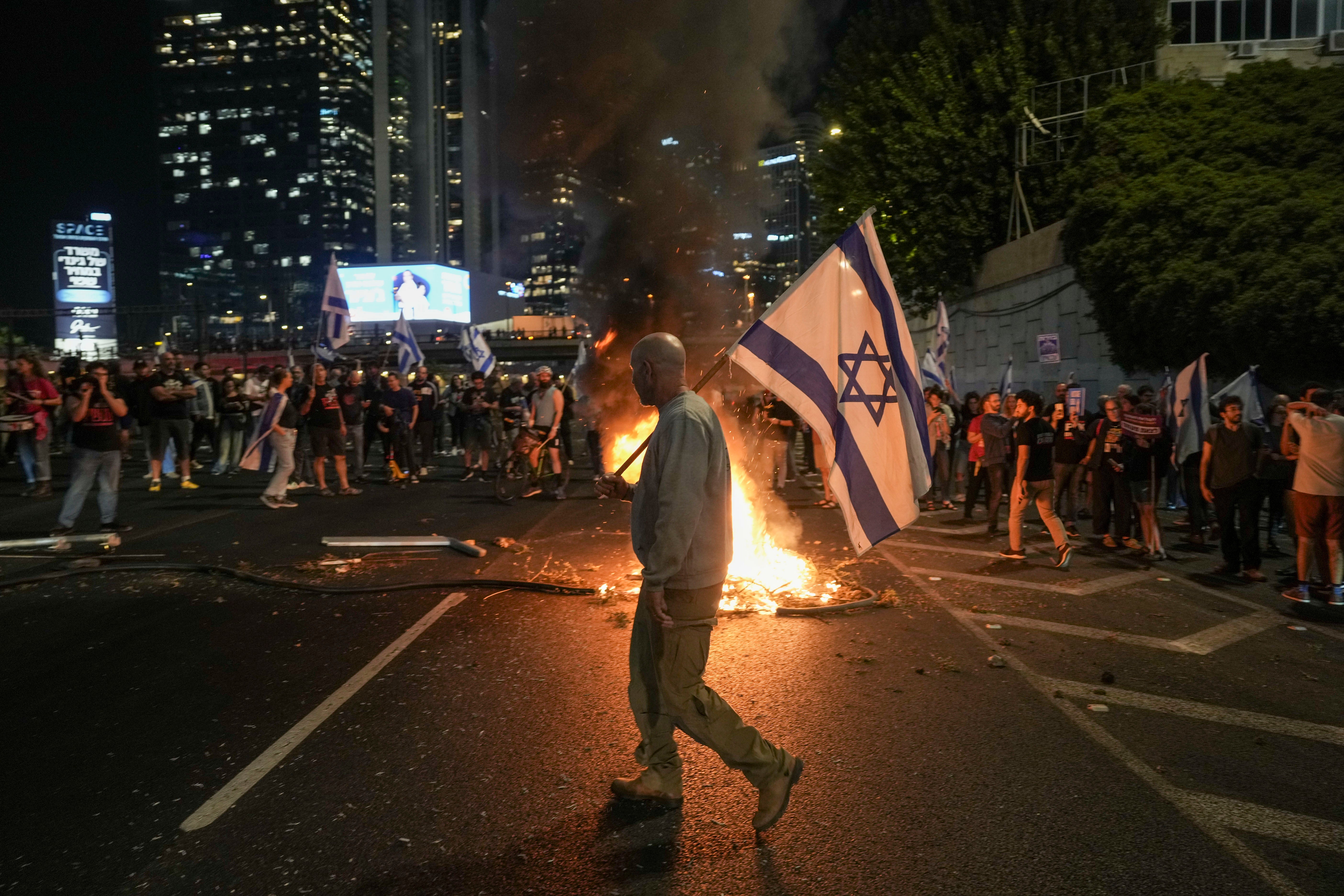 Israelis light a bonfire during a protest after Prime Minister Benjamin Netanyahu has dismissed his popular defense minister Yoav Gallant