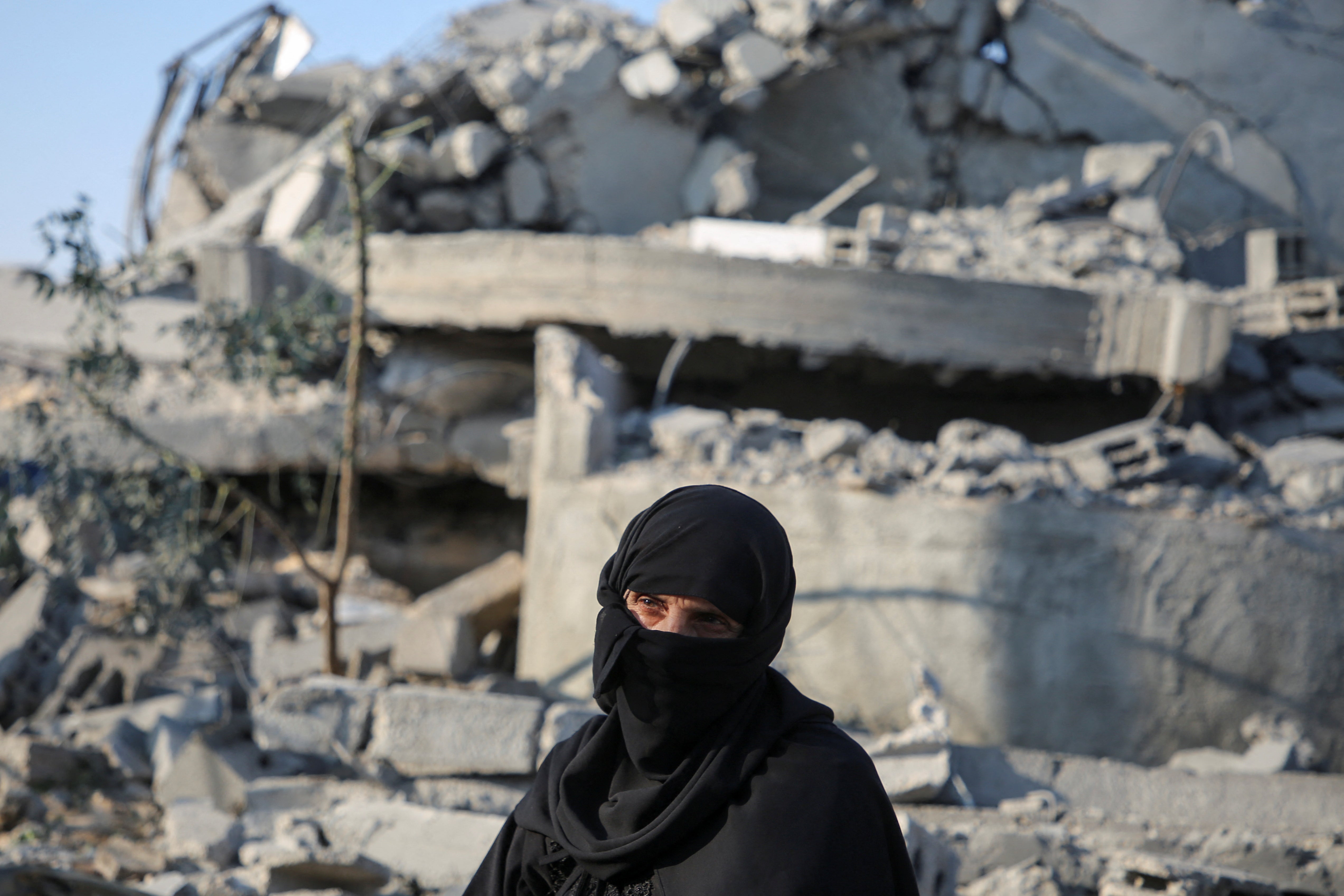 A Palestinian woman looks on at the site of an Israeli strike on a house in the southern Gaza Strip on November 6