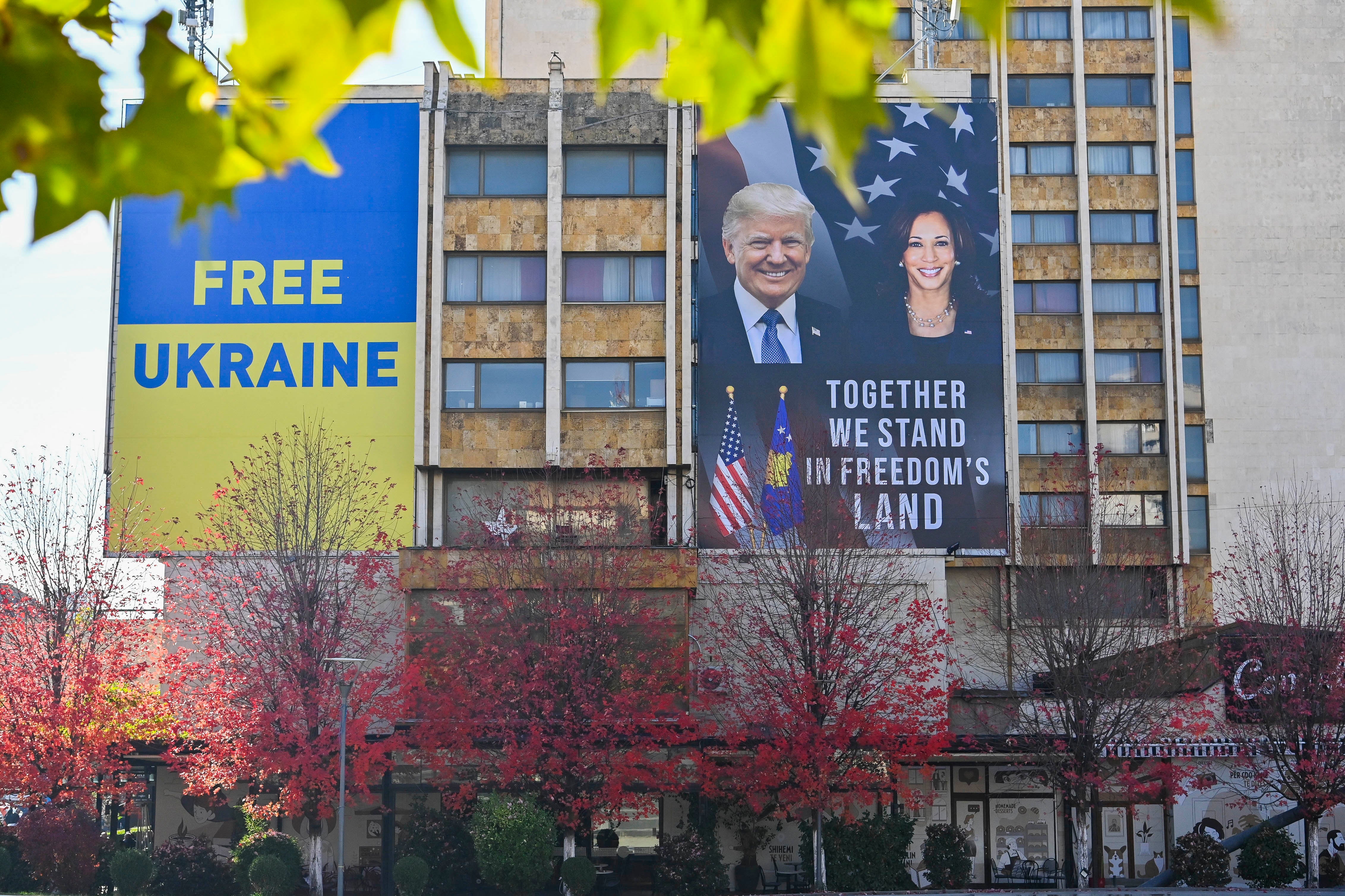 A large banner bearing the portrait of US Vice President and Democratic presidential candidate Kamala Harris and former US President and Republican presidential candidate Donald Trump is displayed