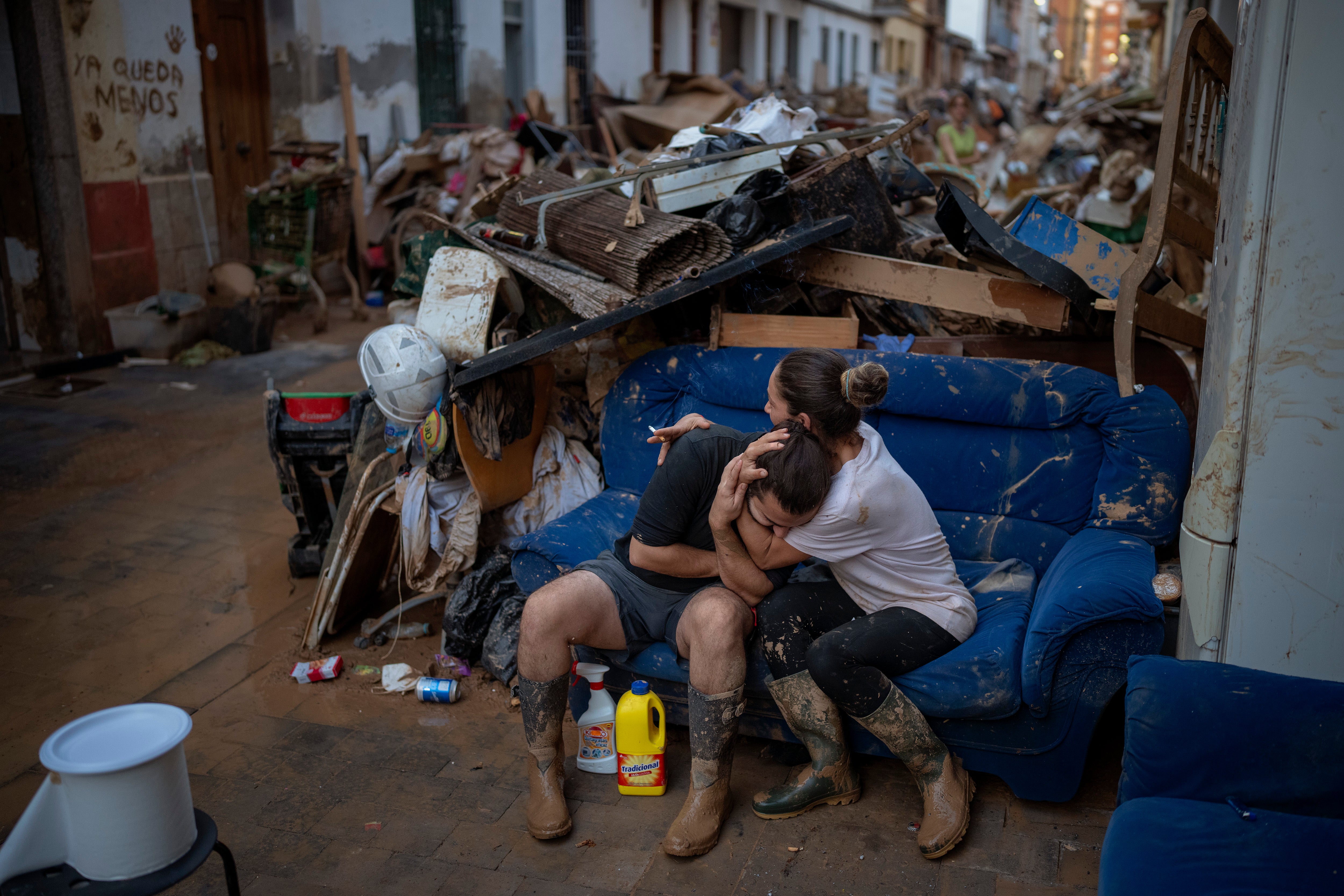 Tania hugs her brother-in-law Baruc after rescuing some of their belongings from their flooded house