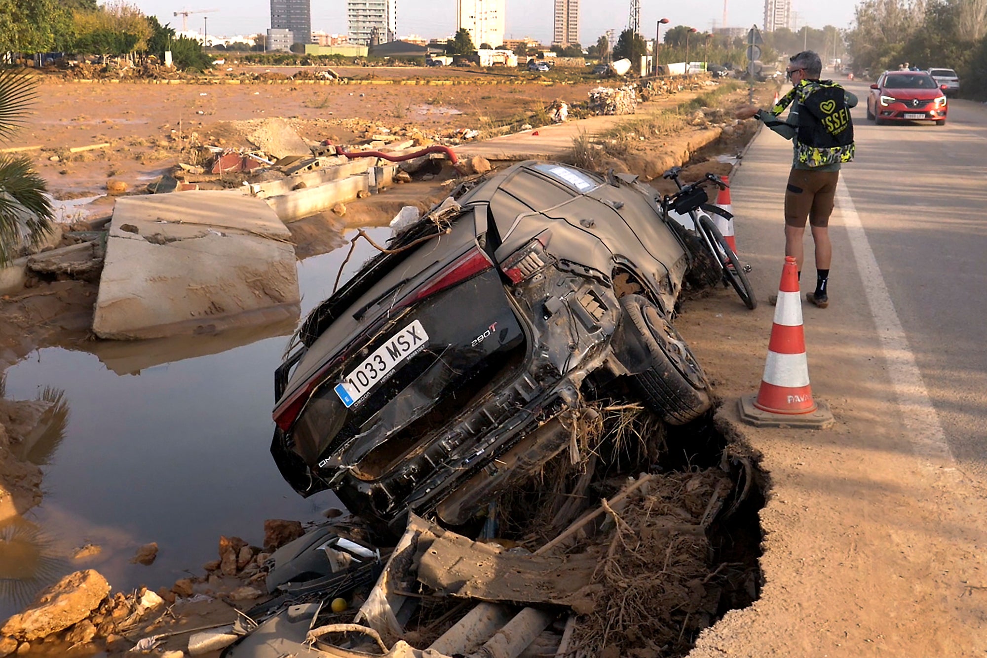 Jorge Tarazona stands next to a car in Paiporta, Valencia, Spain