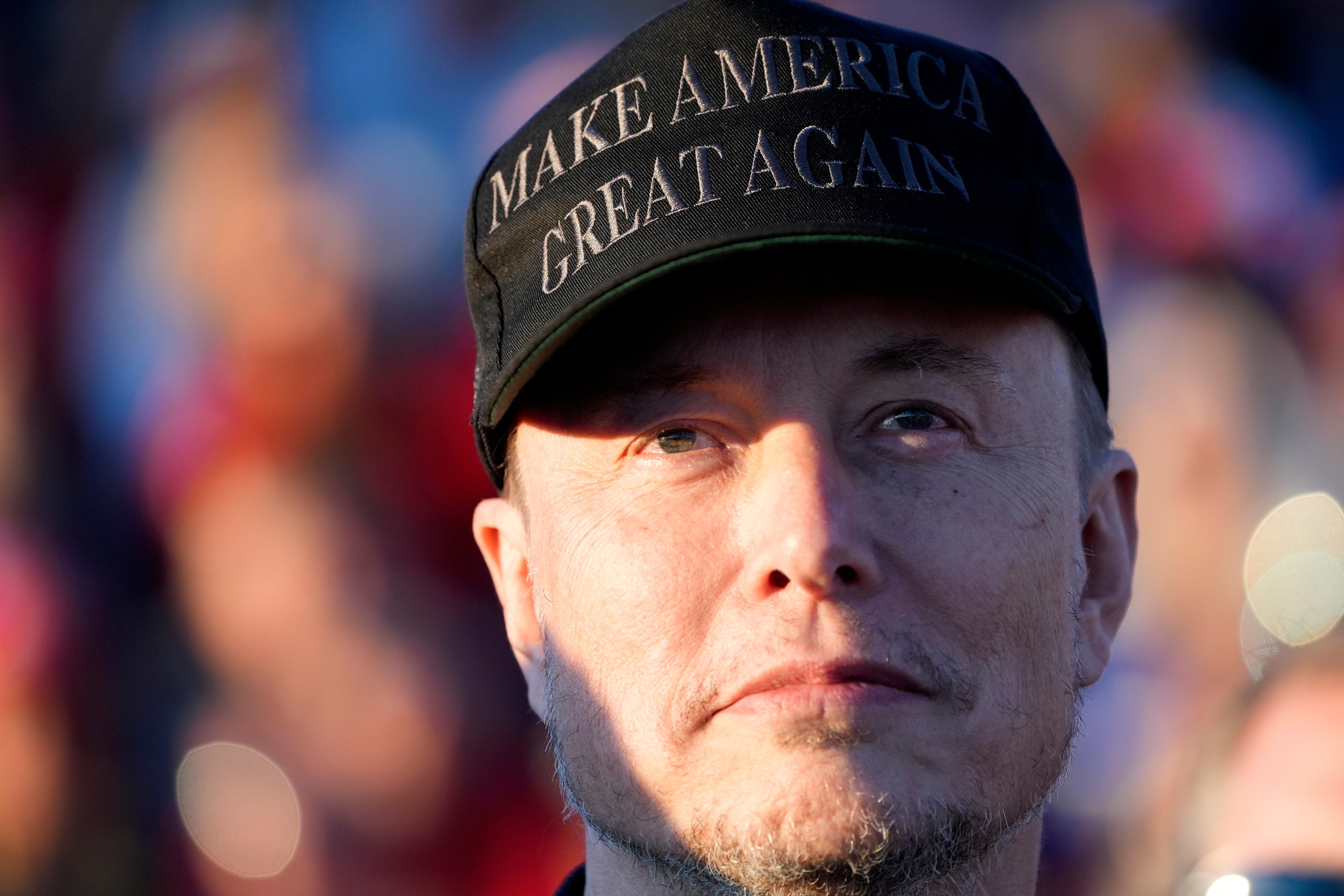 Elon Musk listens as Donald Trump speaks at a campaign event on Oct. 5, 2024, in Butler, PA