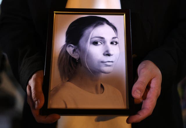 <p>A colleague of Ukrainian journalist Victoria Roshchyna holds a photograph of her during an event in her honour at a makeshift memorial for fallen Ukrainian soldiers, at Independence Square in Kyiv</p>