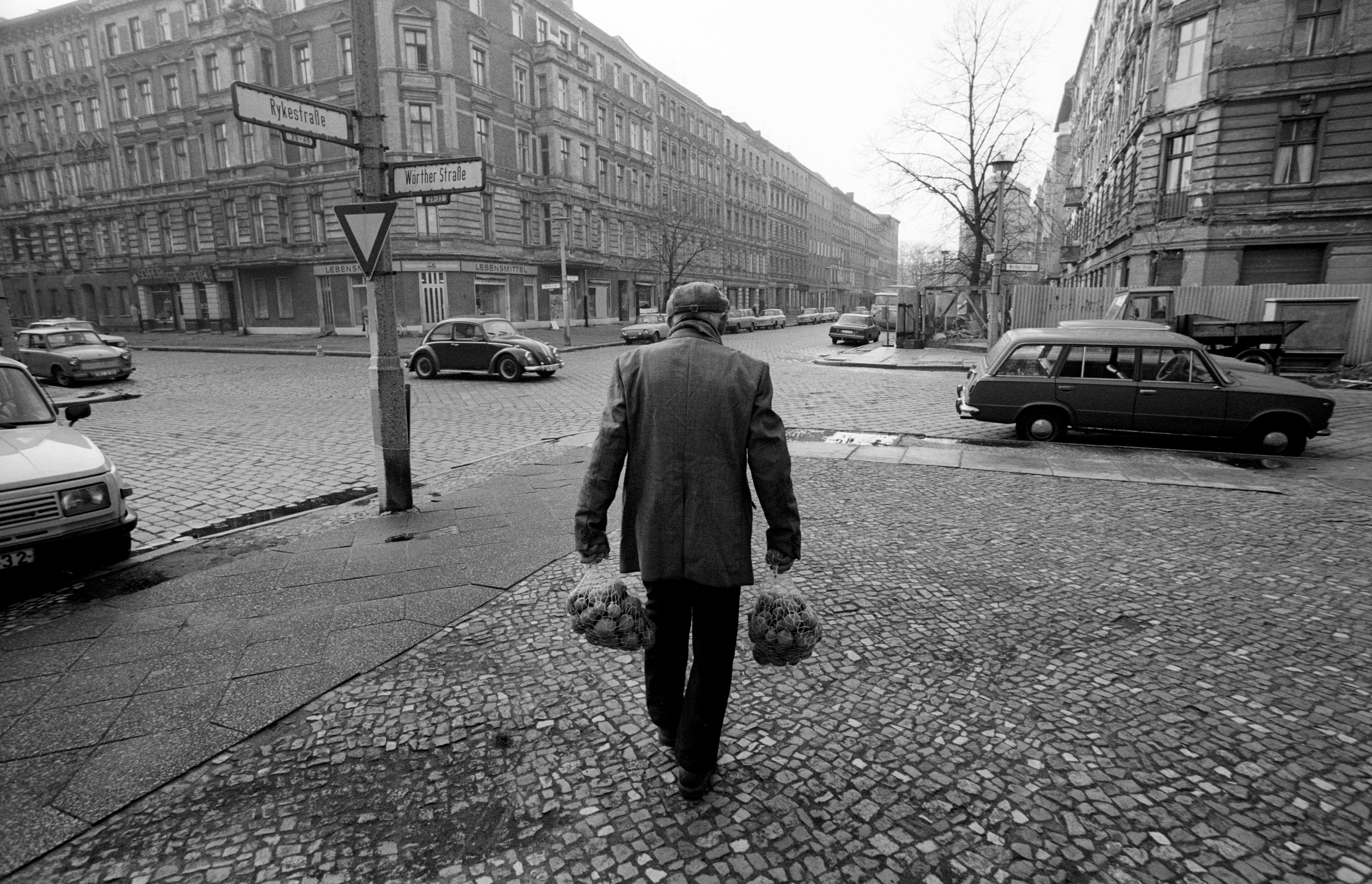 East Berlin before the fall: an elderly man carries shopping bags full of potatoes, 7 November 1989