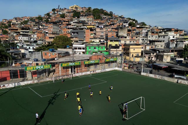 <p>Betting company advertisements adorn a soccer field during a training program run by non-governmental organization "Cara a Cara" in the Complexo do Alemao favela, in Rio de Janeiro, Brazil</p>